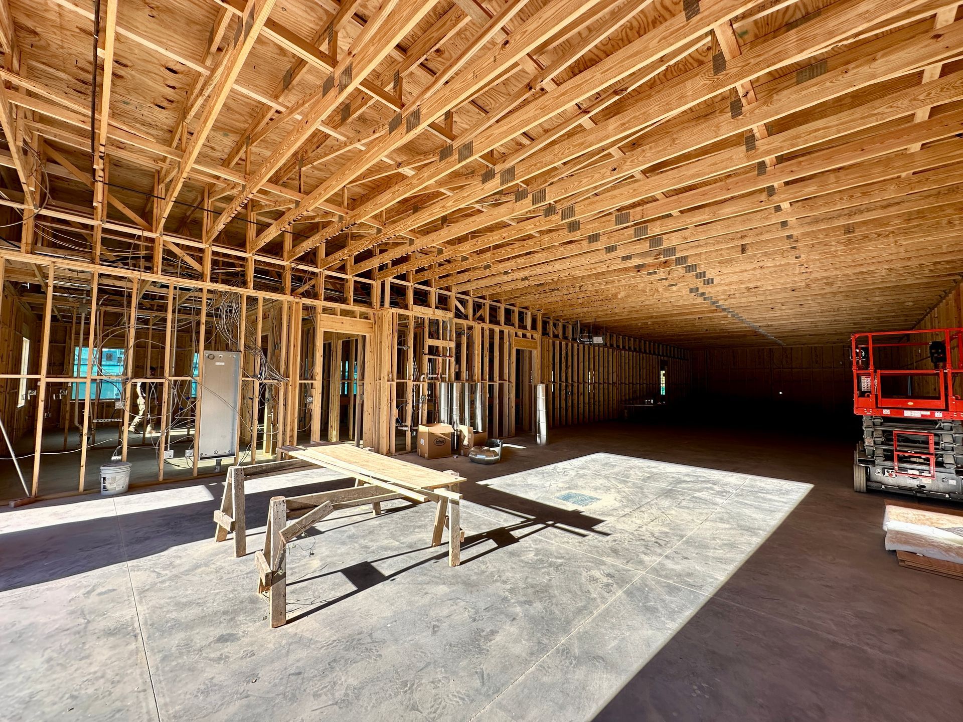 Interior of a building under construction, showing wooden framing and concrete floor.
