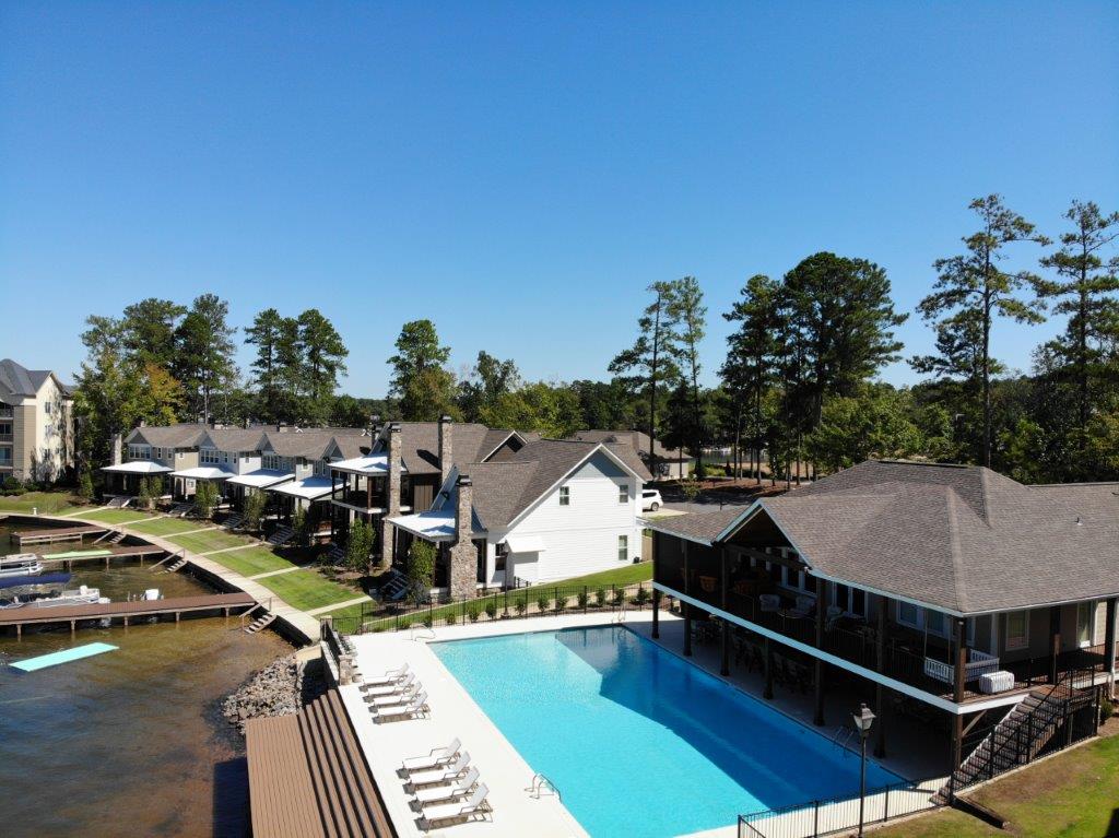 An aerial view of a large swimming pool surrounded by houses and trees
