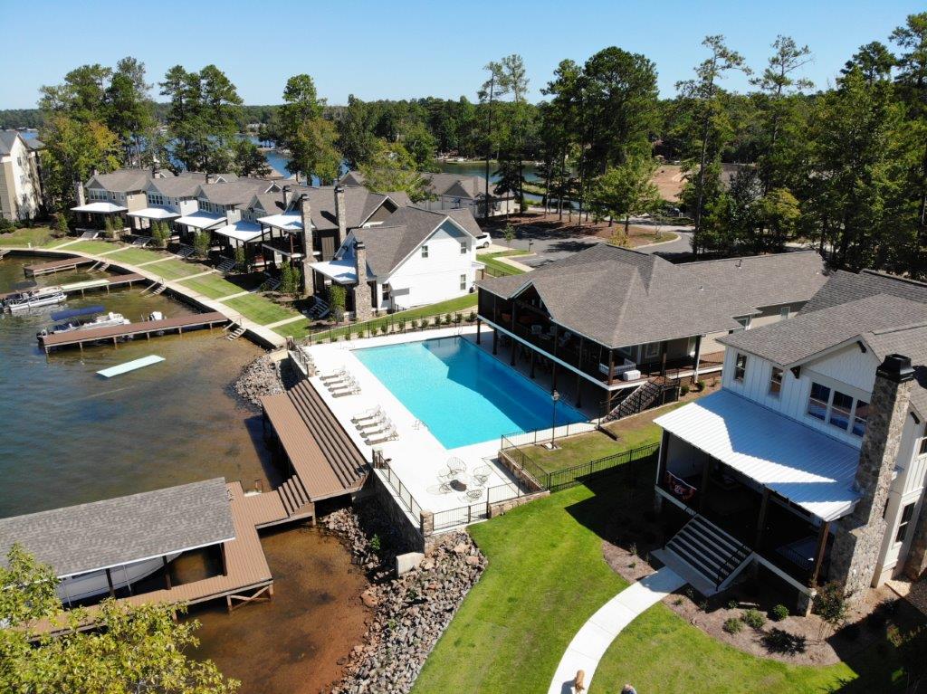 An aerial view of a swimming pool surrounded by houses and trees