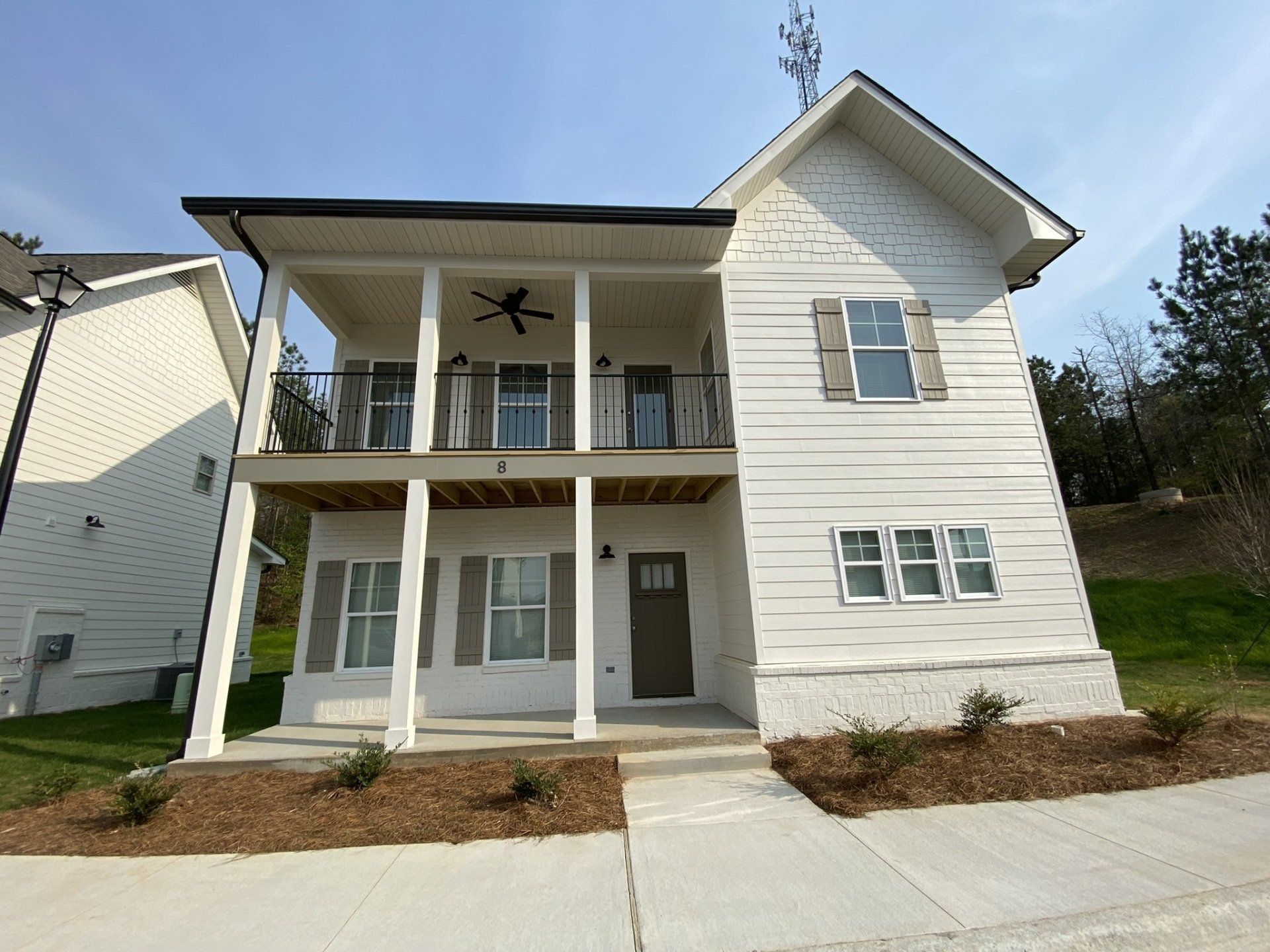 A white house with a balcony and a ceiling fan
