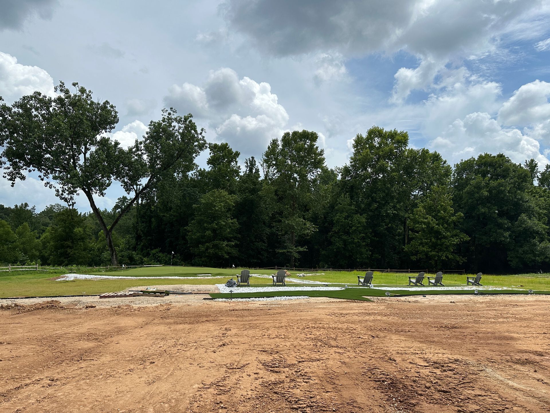 A dirt field with a lot of trees in the background