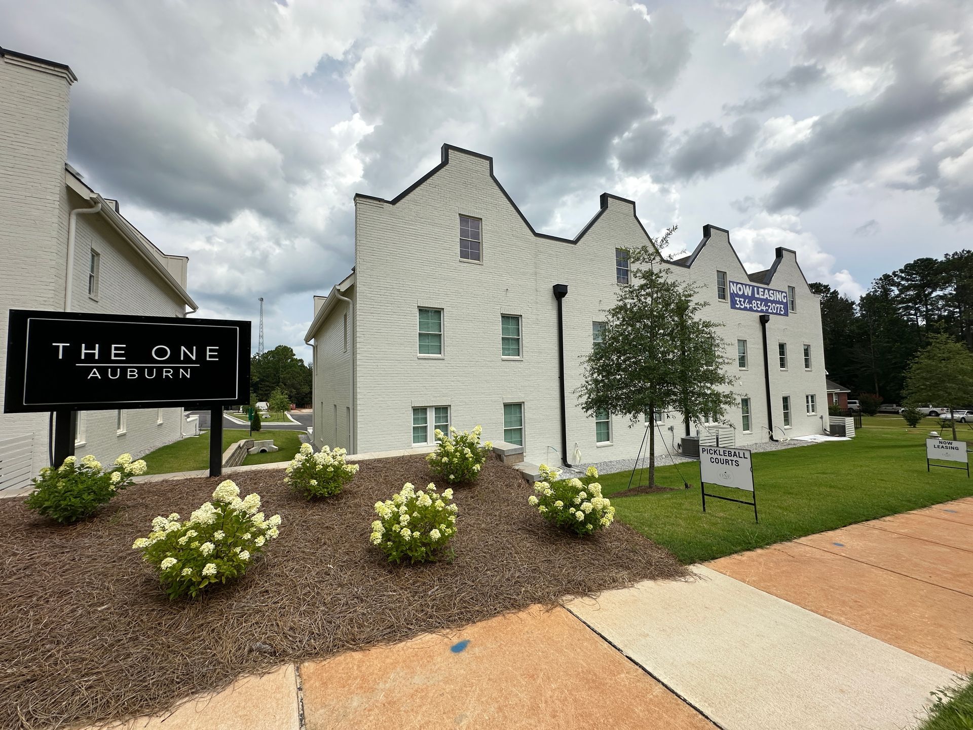 A white building with a sign that says the one auburn