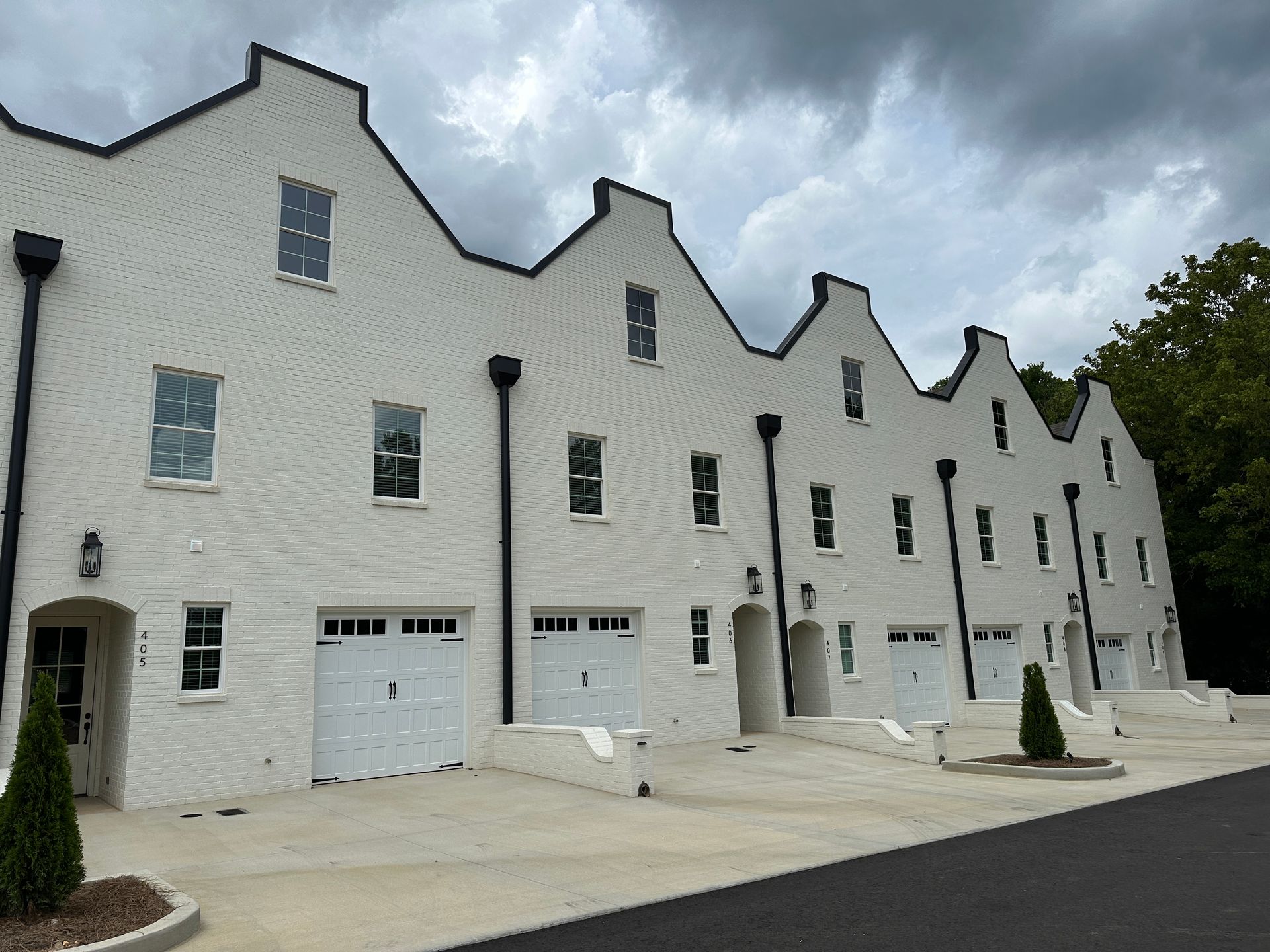 A row of white houses with black trim are lined up next to each other.