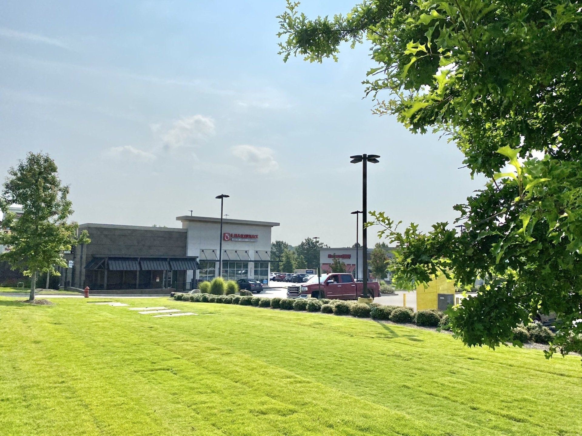 A large grassy field with a building in the background
