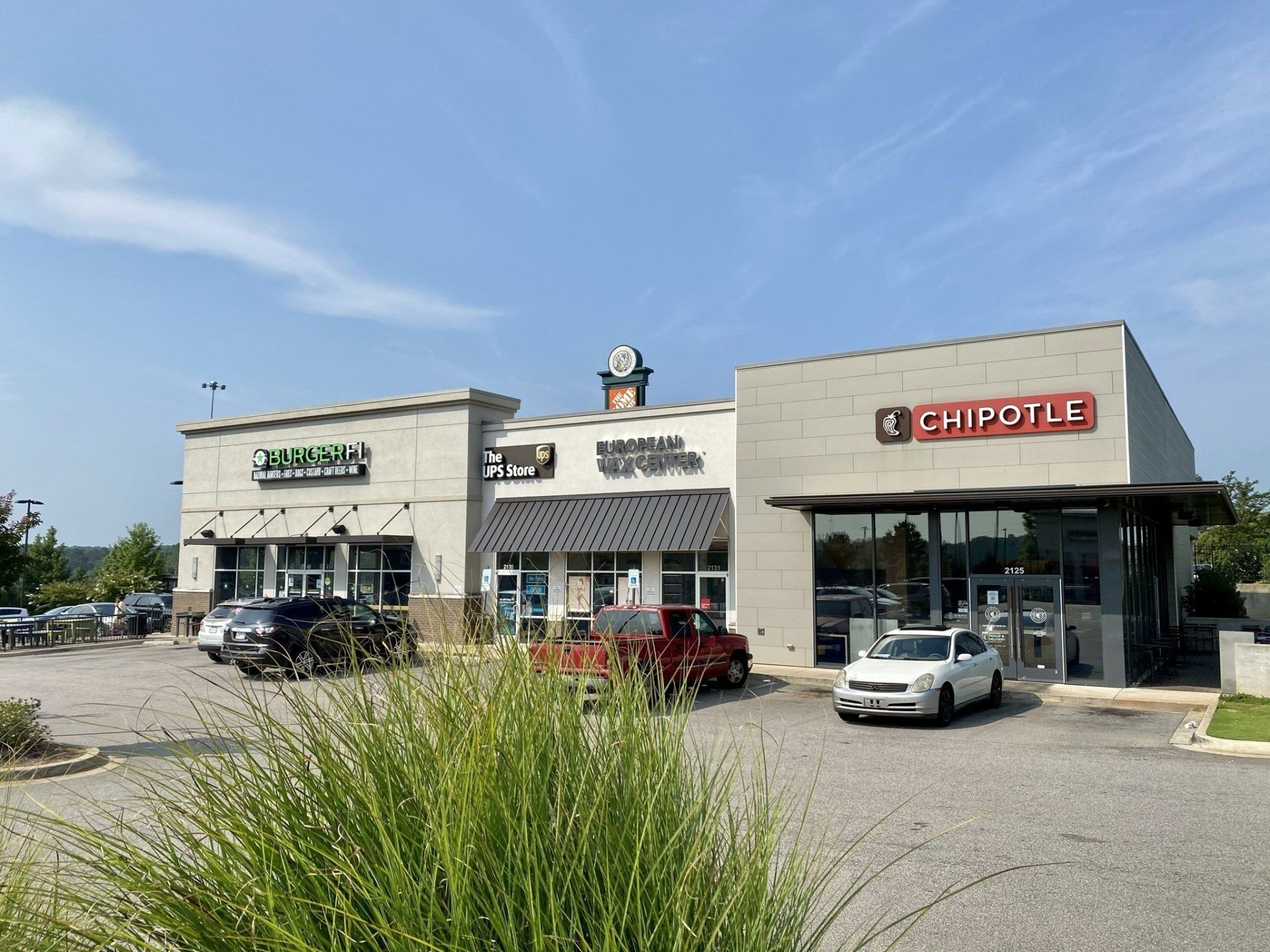 A chipotle restaurant is located in the middle of a shopping center.
