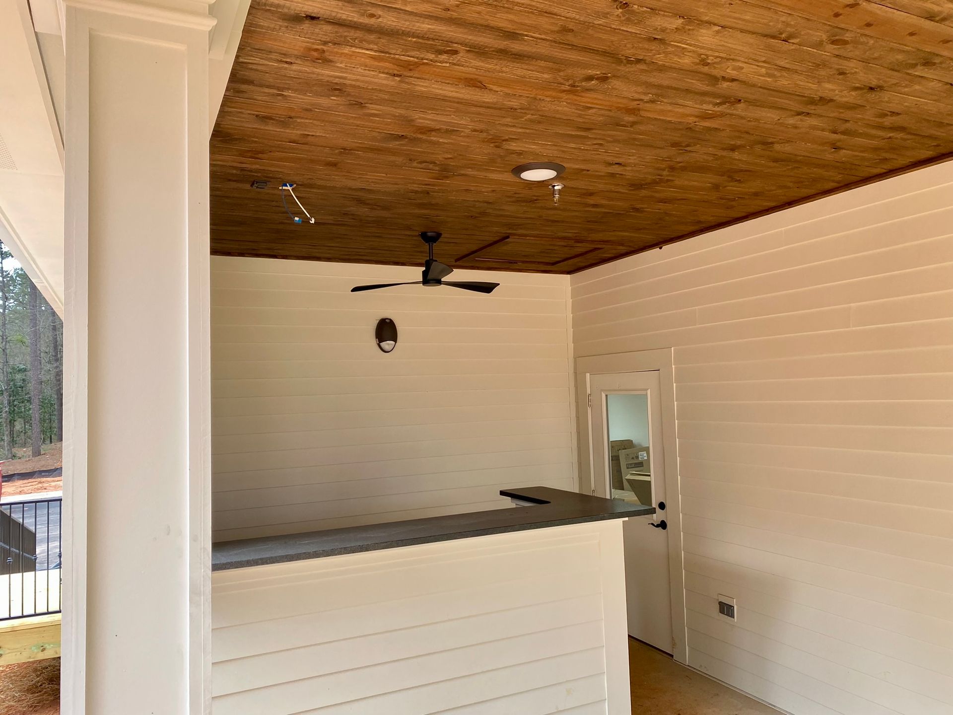 A room with a wooden ceiling and a ceiling fan.