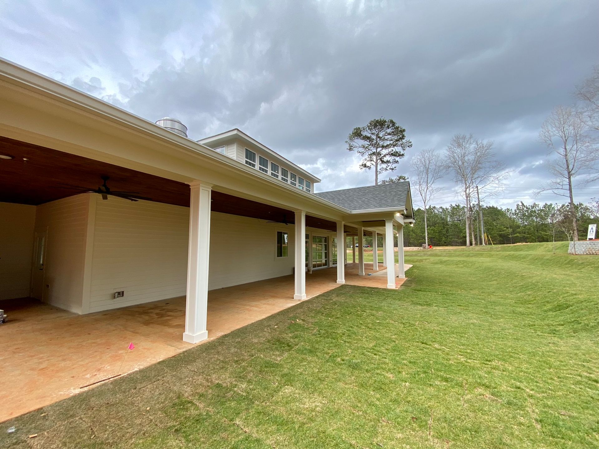 A large house with a covered porch and a large lawn in front of it.