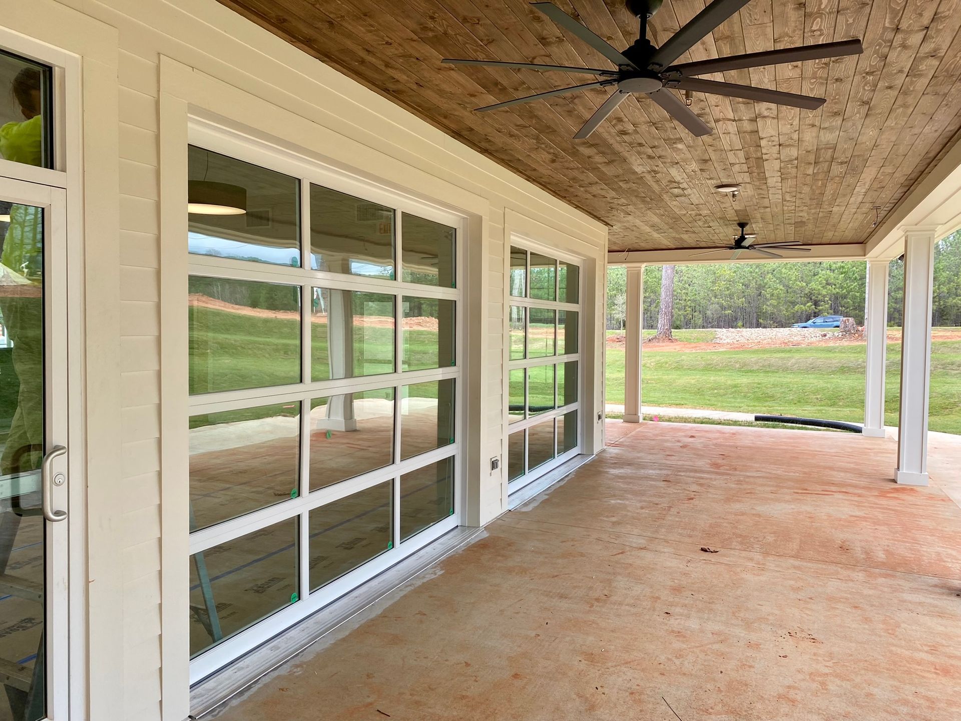A large porch with a lot of windows and a ceiling fan.