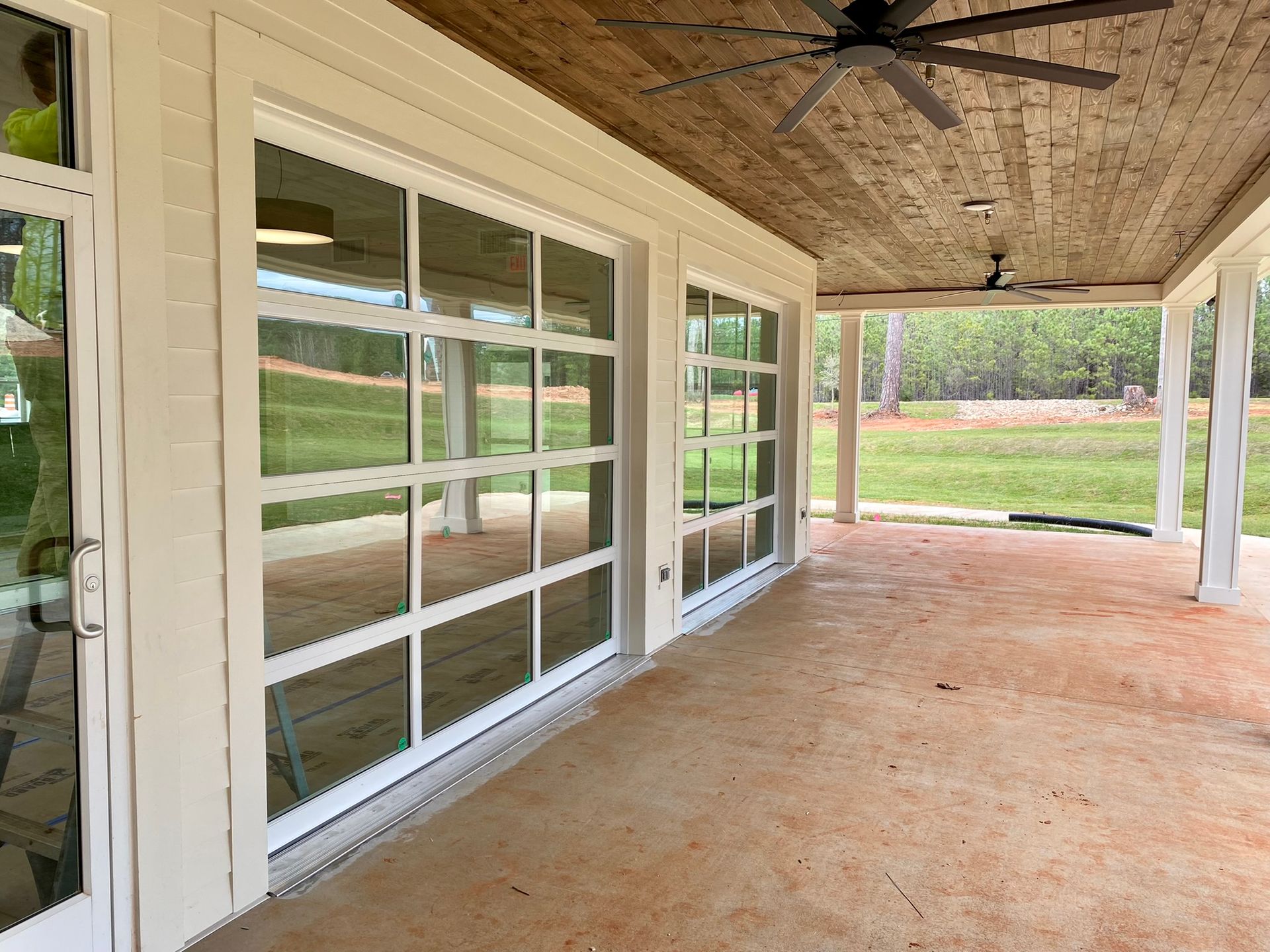 A large porch with a lot of windows and a ceiling fan.