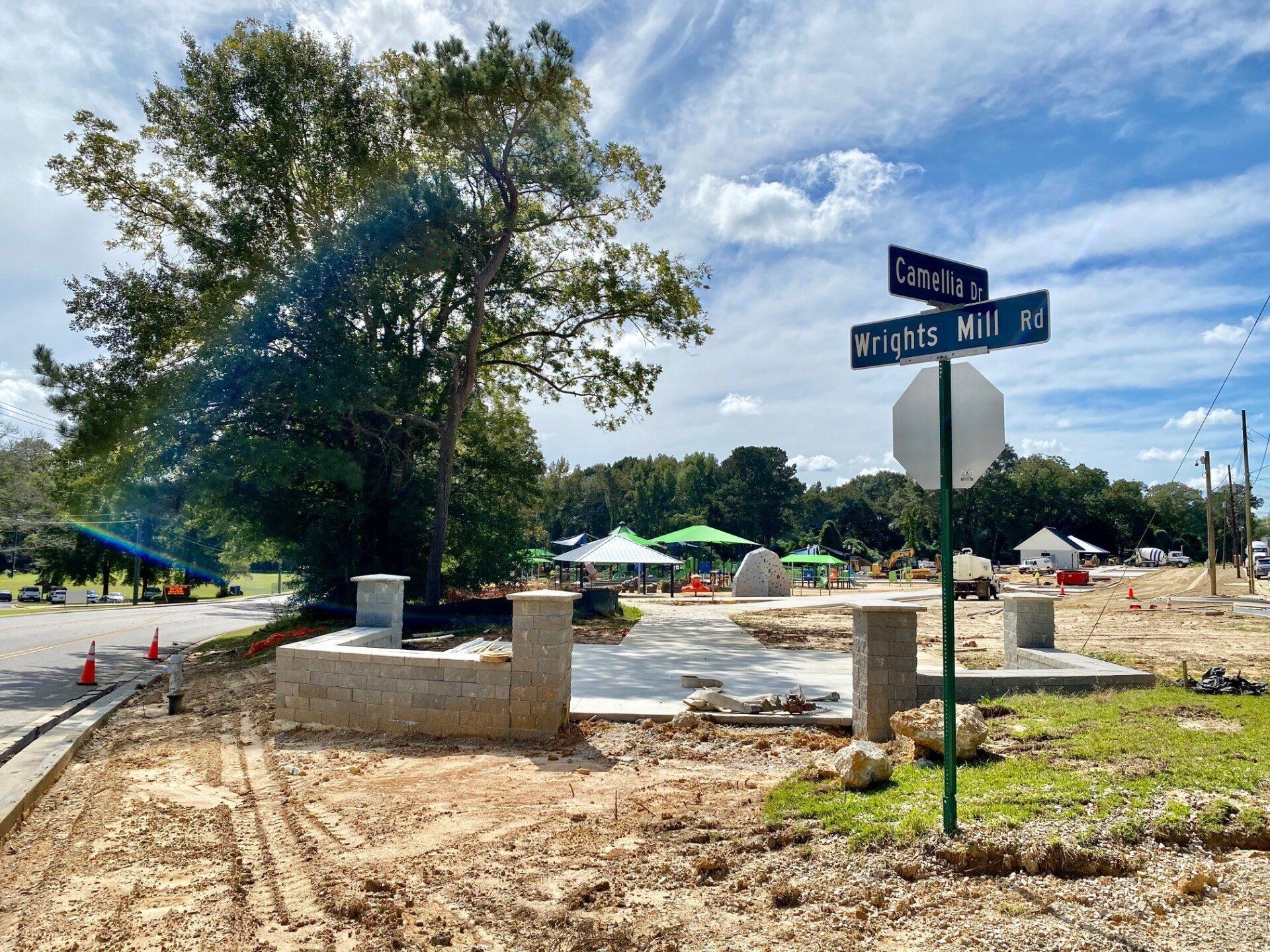 A street sign for wright 's mill is in the middle of a dirt field.