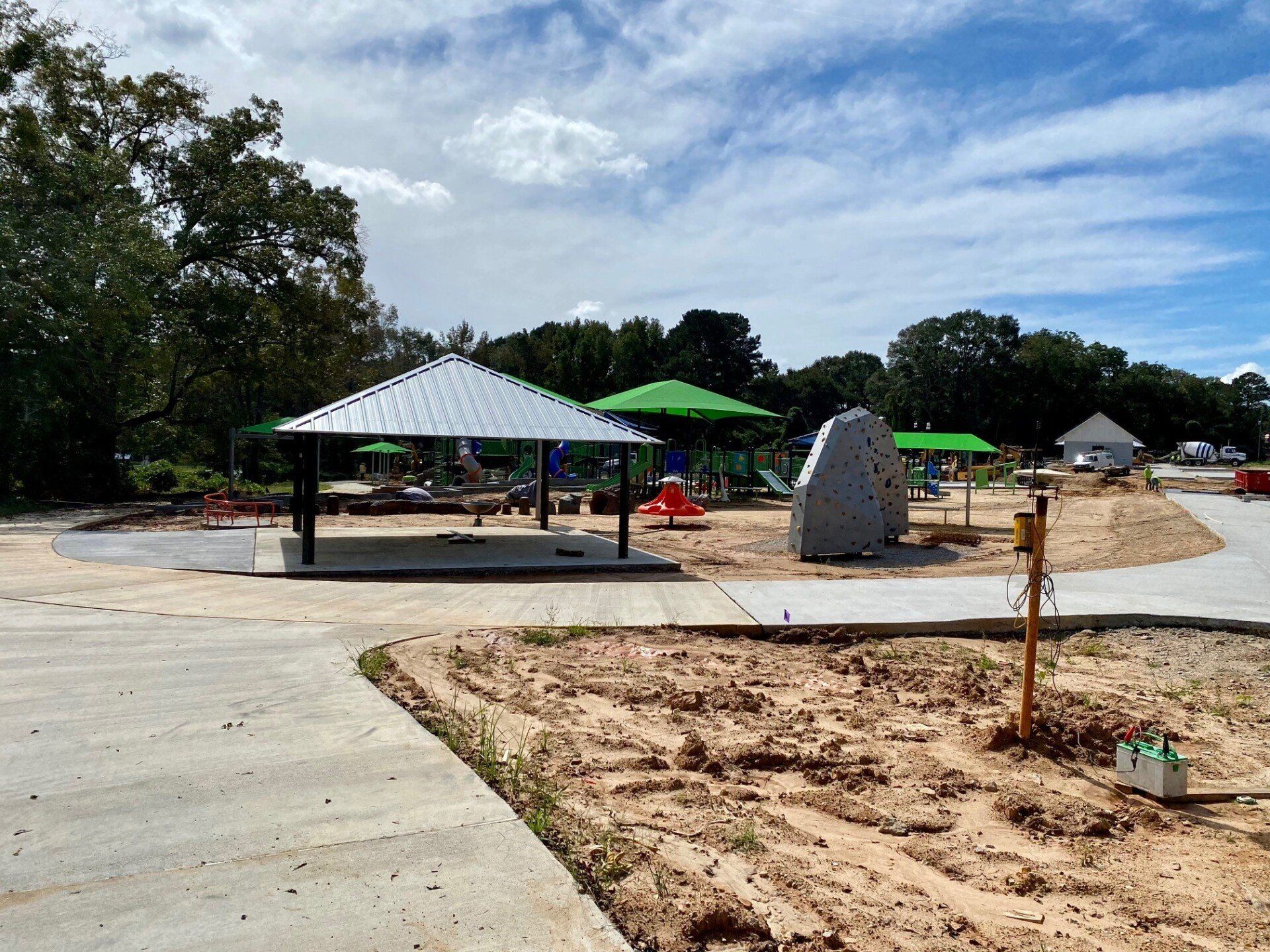 A playground with a gazebo and umbrellas in the middle of it