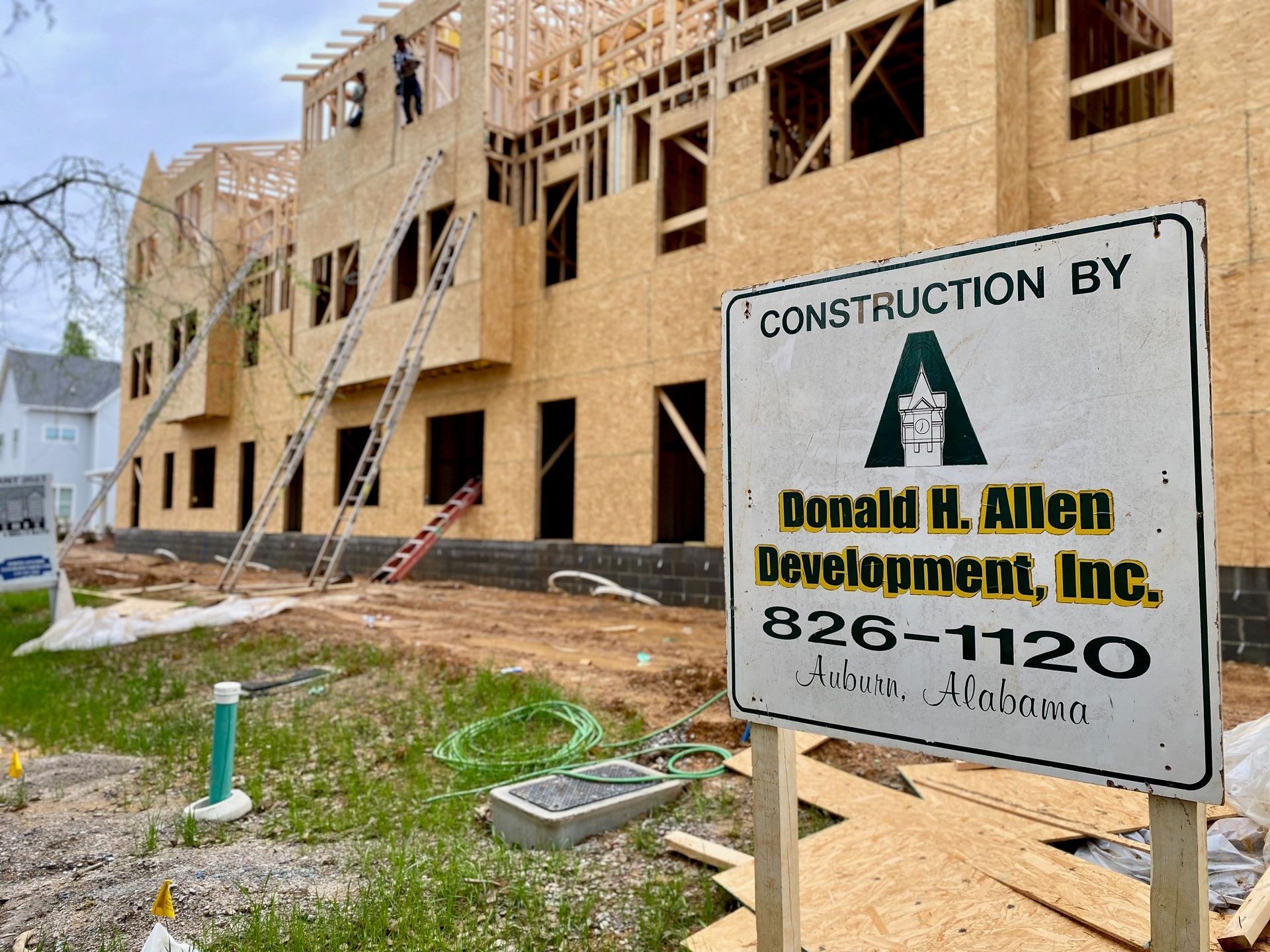 A construction sign is in front of a building under construction.