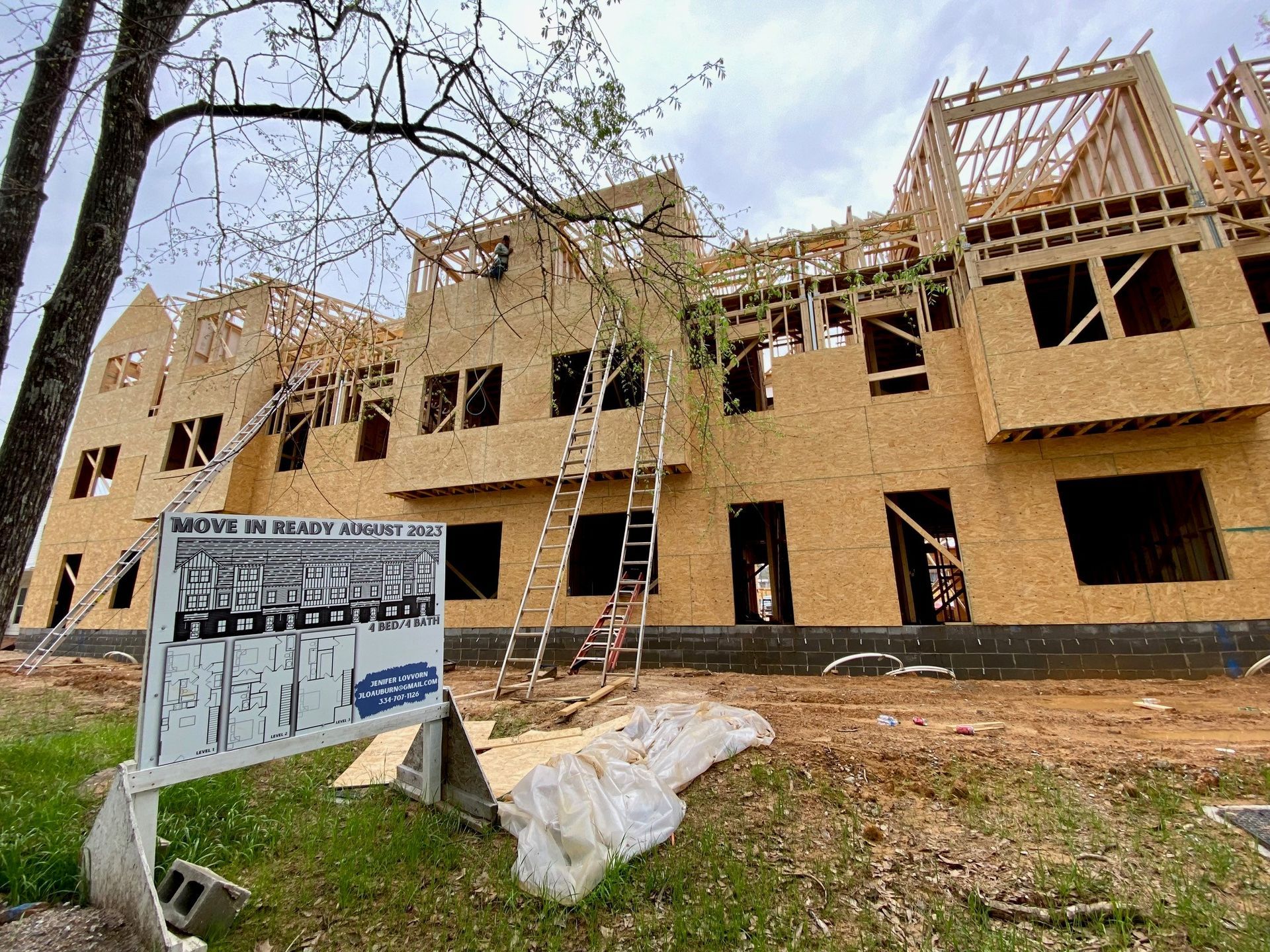 A large building under construction with a sign in front of it.