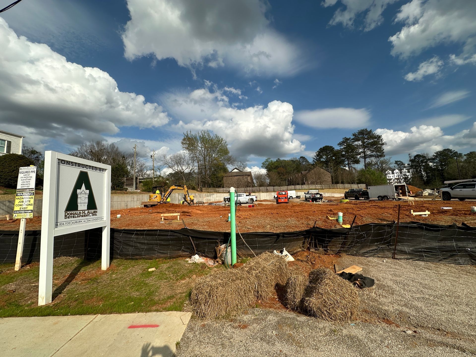 An aerial view of a new Hovey Precast office building with a blue roof surrounded by trees.