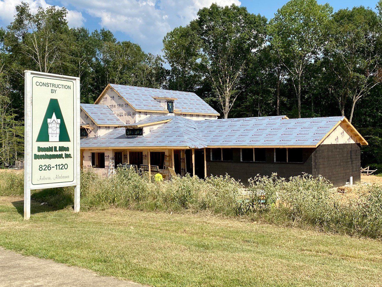A house under construction with a sign in front of it.
