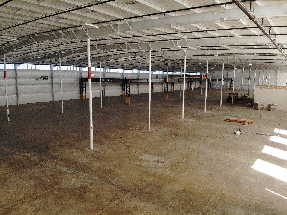 A large empty warehouse with a concrete floor