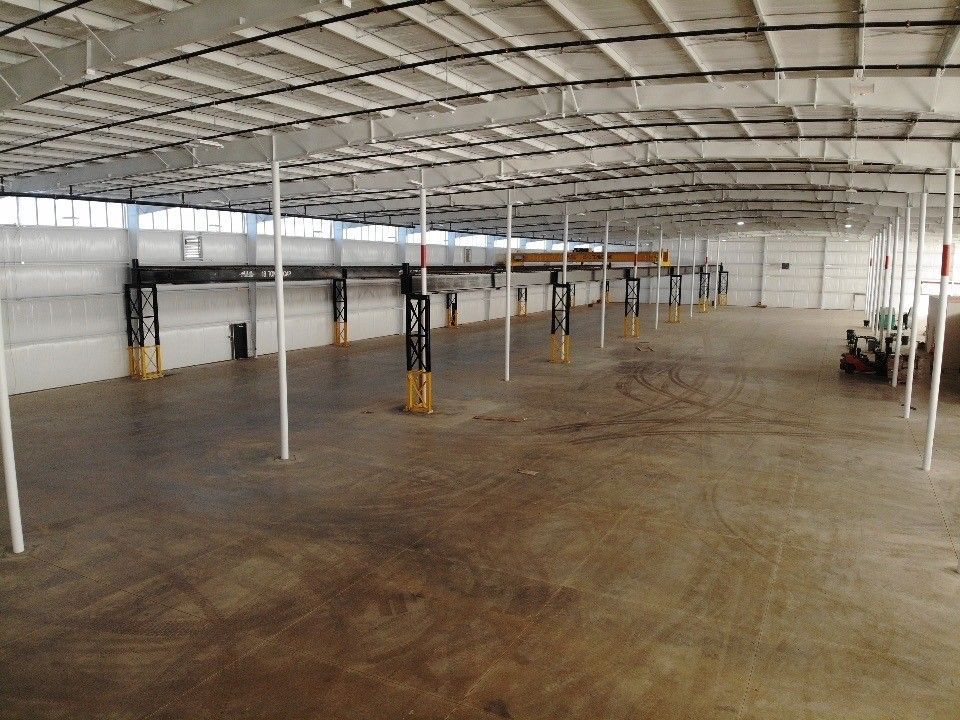 A large empty warehouse with a white ceiling