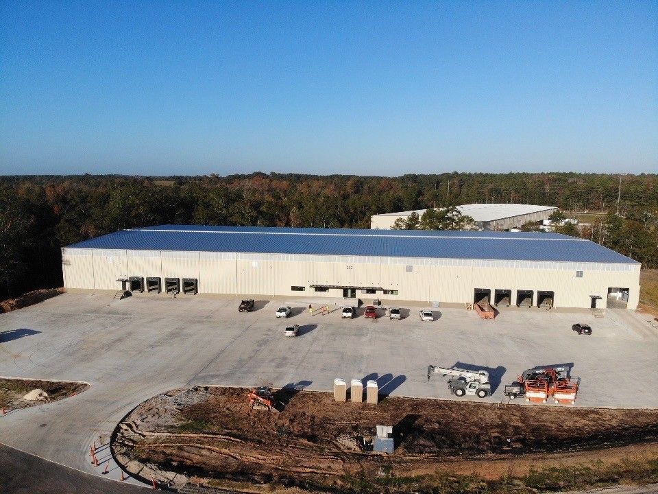 An aerial view of a large building with a parking lot in front of it.
