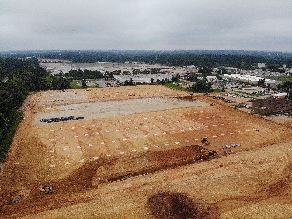 An aerial view of a large dirt field in a city.