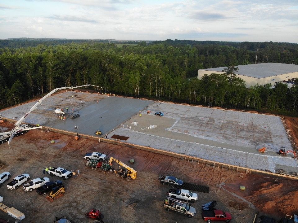 An aerial view of a construction site with trucks parked in front of it.