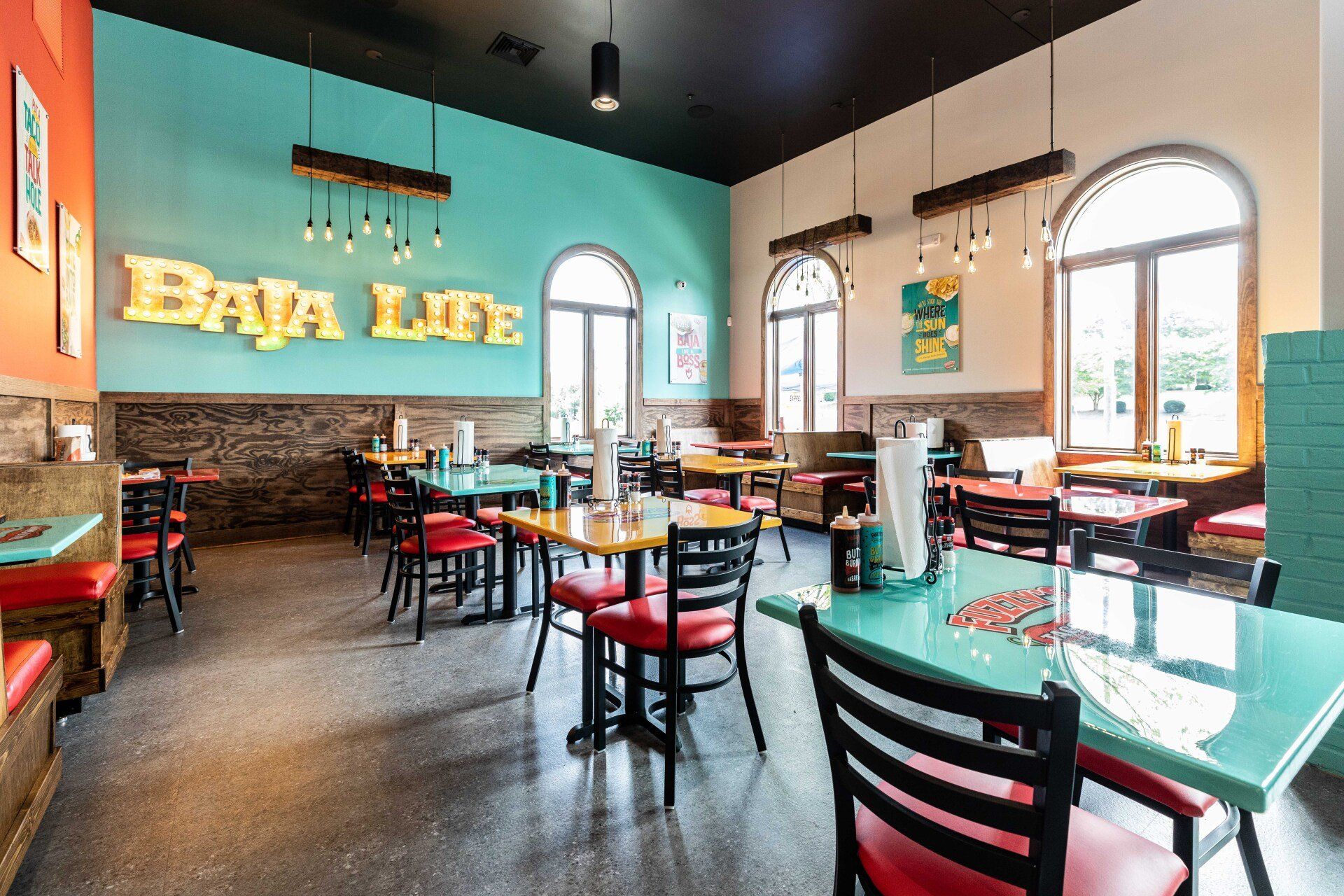 A restaurant with tables and chairs and a sign that says baja life.