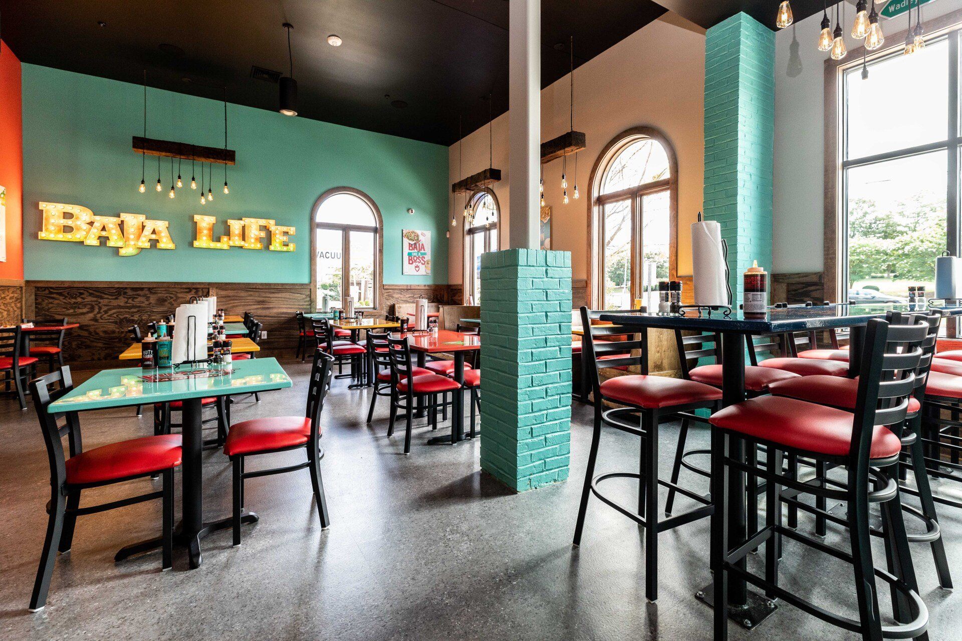 A restaurant with tables and chairs and a sign that says baja life.