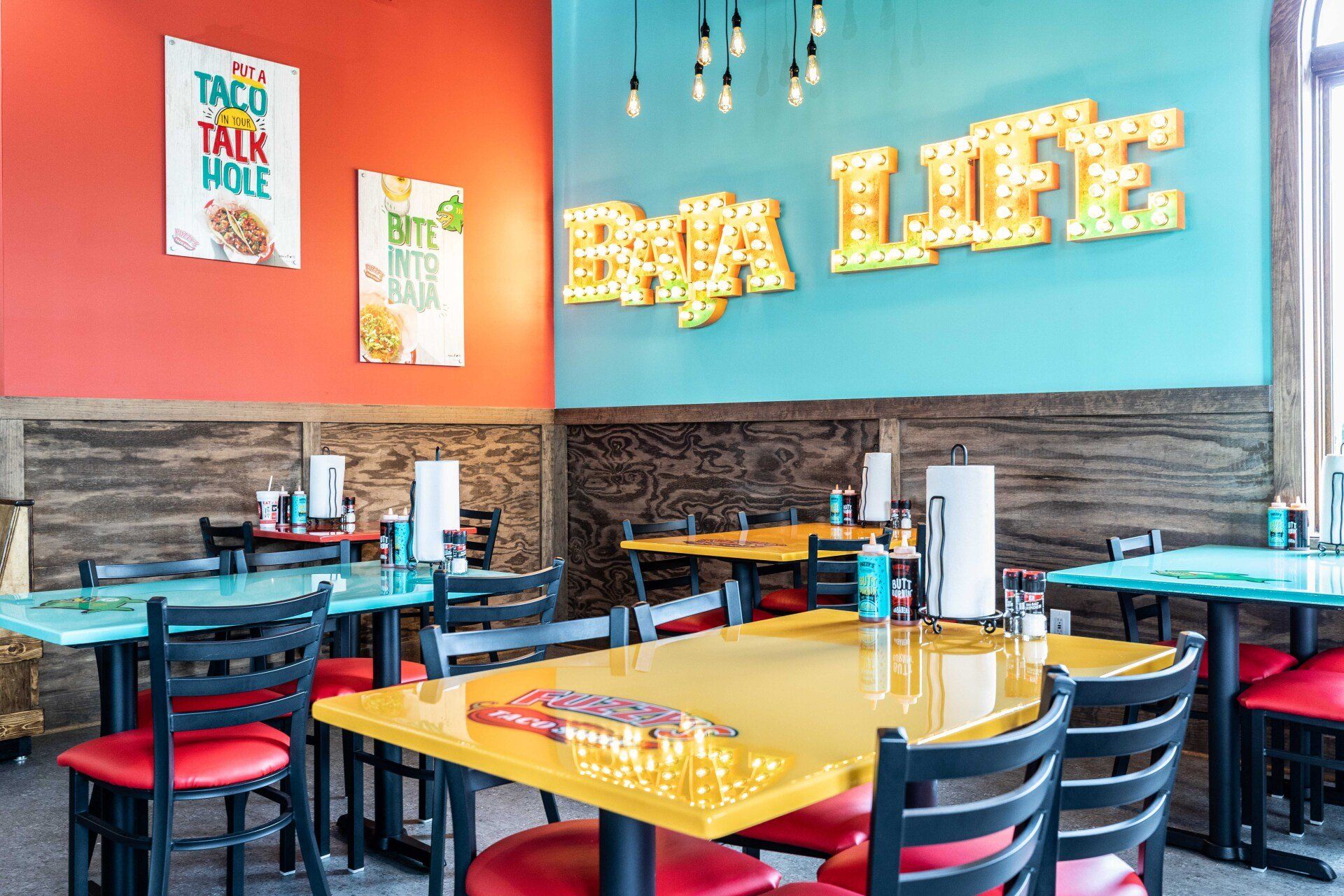 A restaurant with tables and chairs and a sign that says `` big life '' on the wall.
