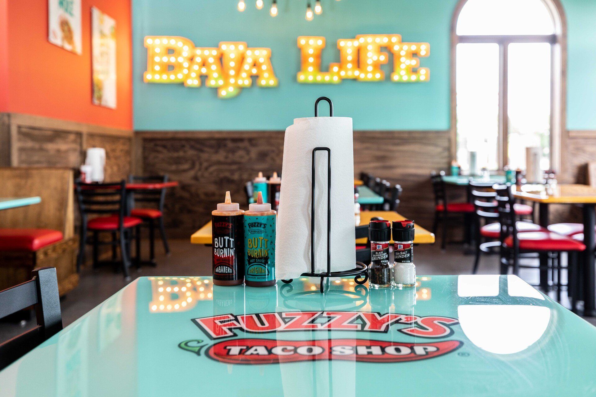 A restaurant with tables and chairs and a sign that says baja life.