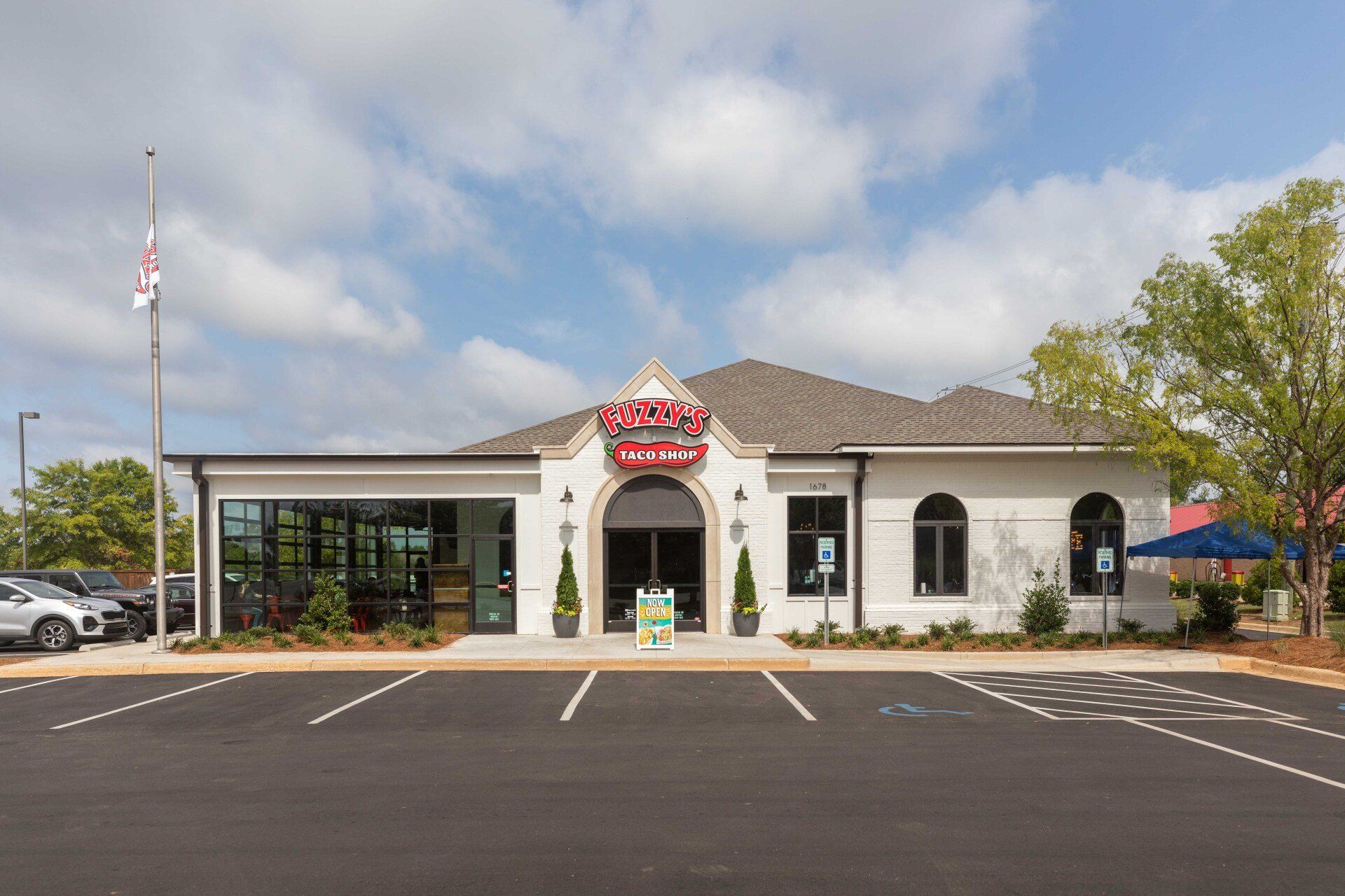 A large white building with a parking lot in front of it.