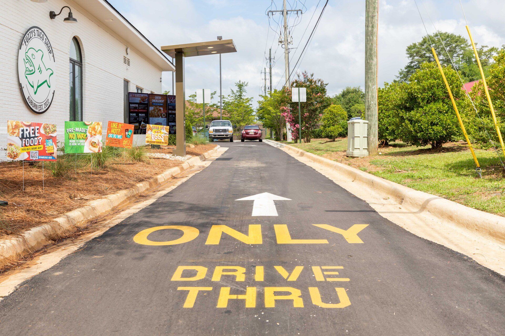 A drive thru sign is painted on the side of a road.