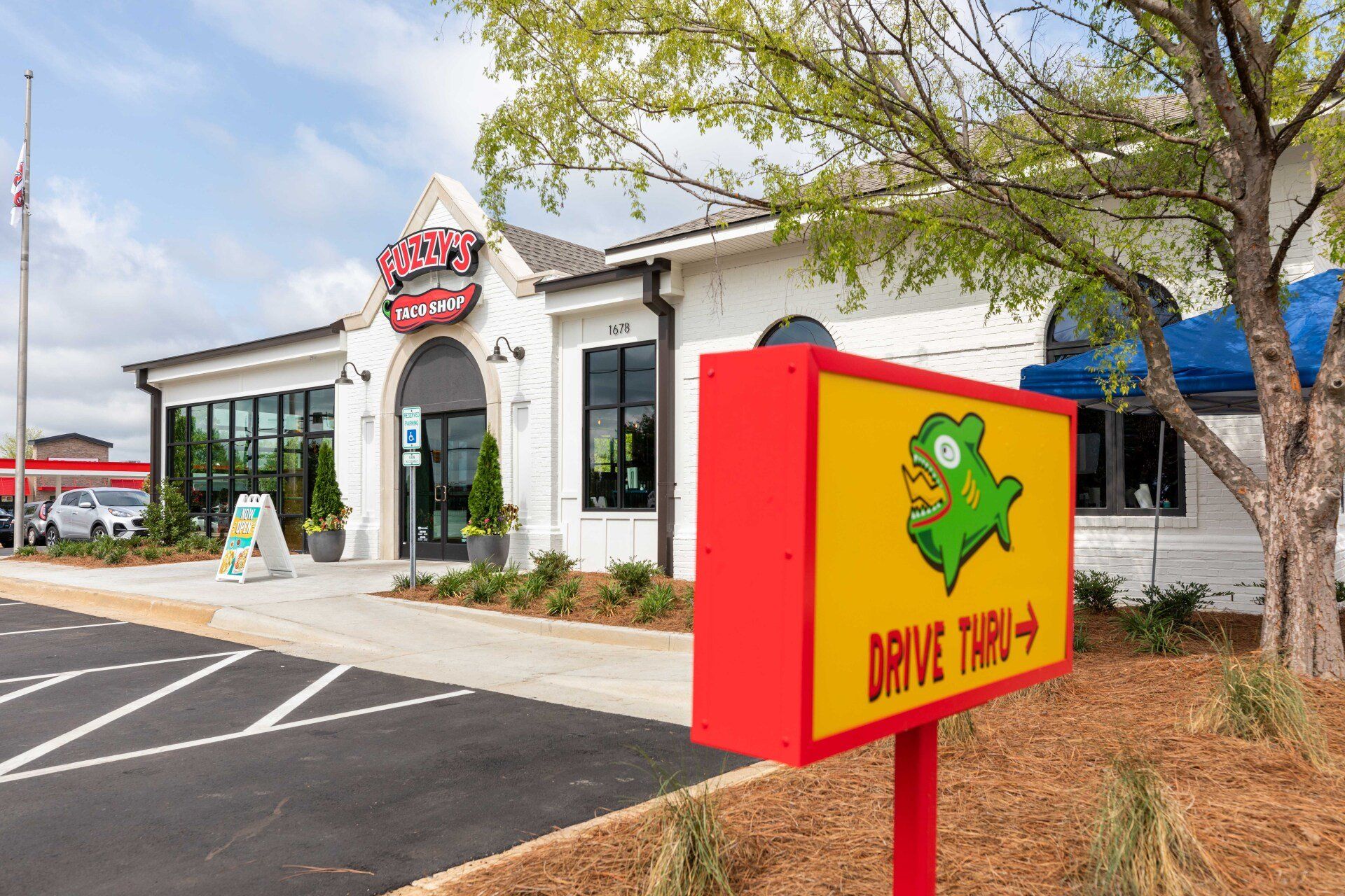 A restaurant with a drive thru sign in front of it.