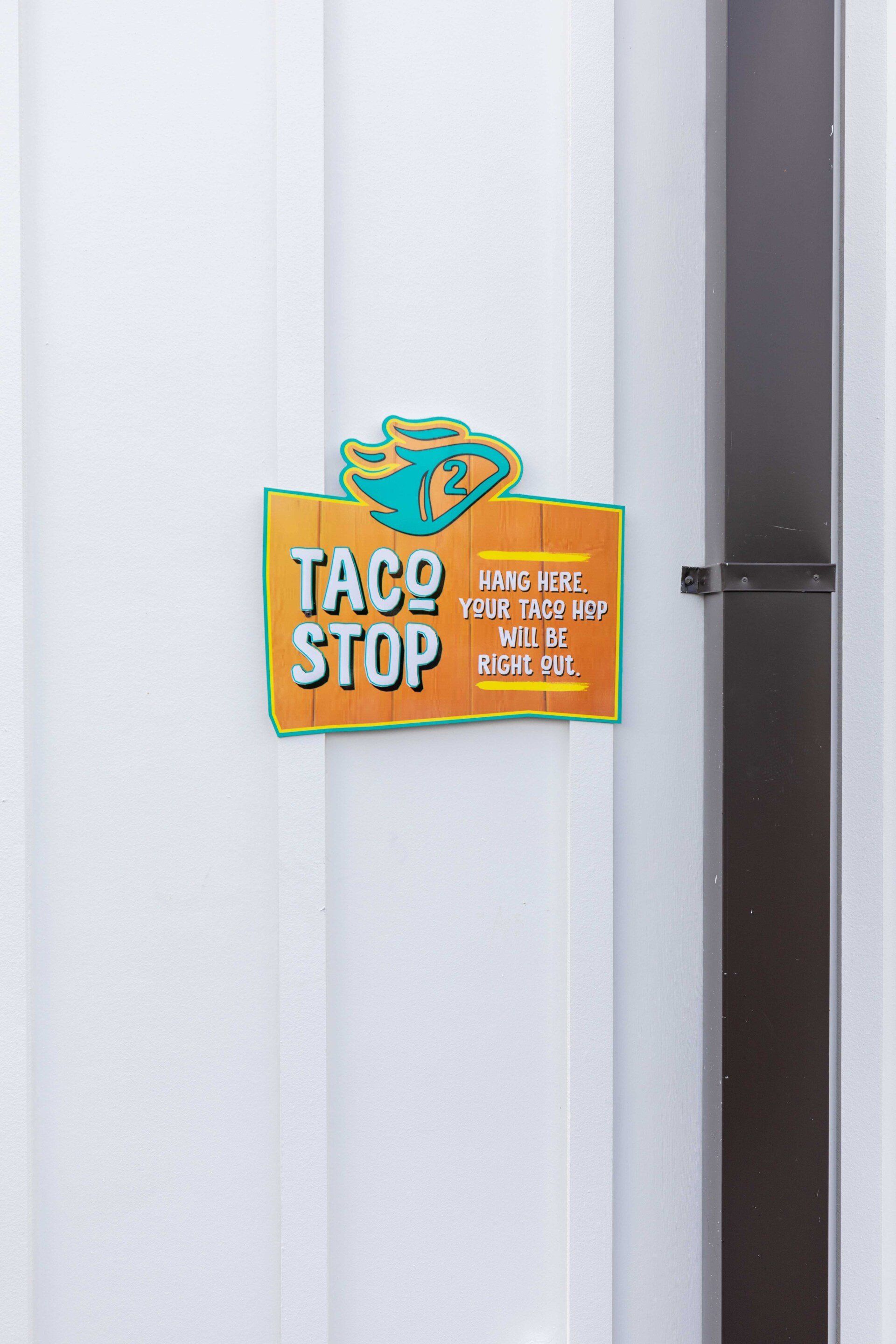 A taco stop sign is on the side of a building.