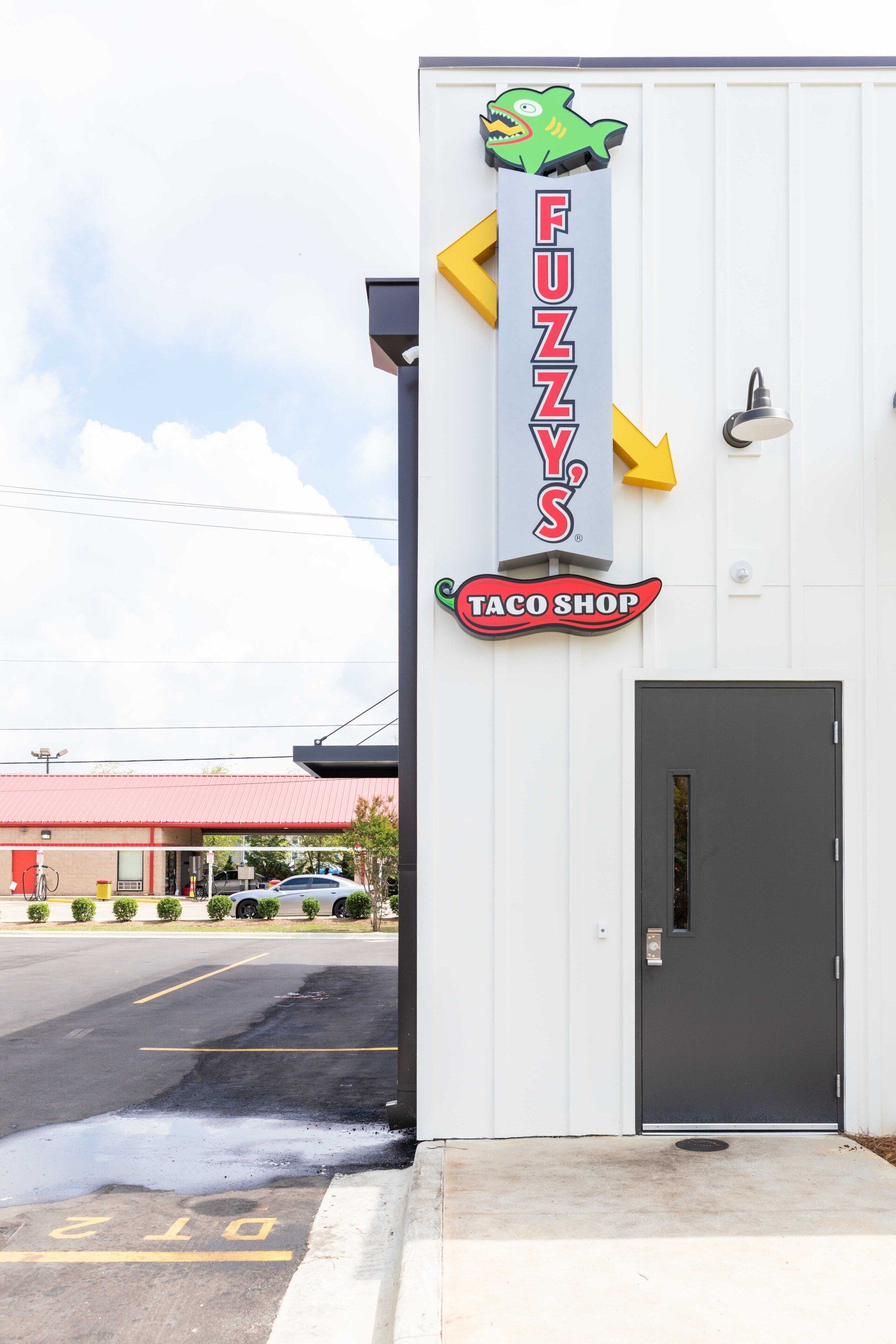 A white building with a sign on the side that says `` funky 's taxi shop ''.