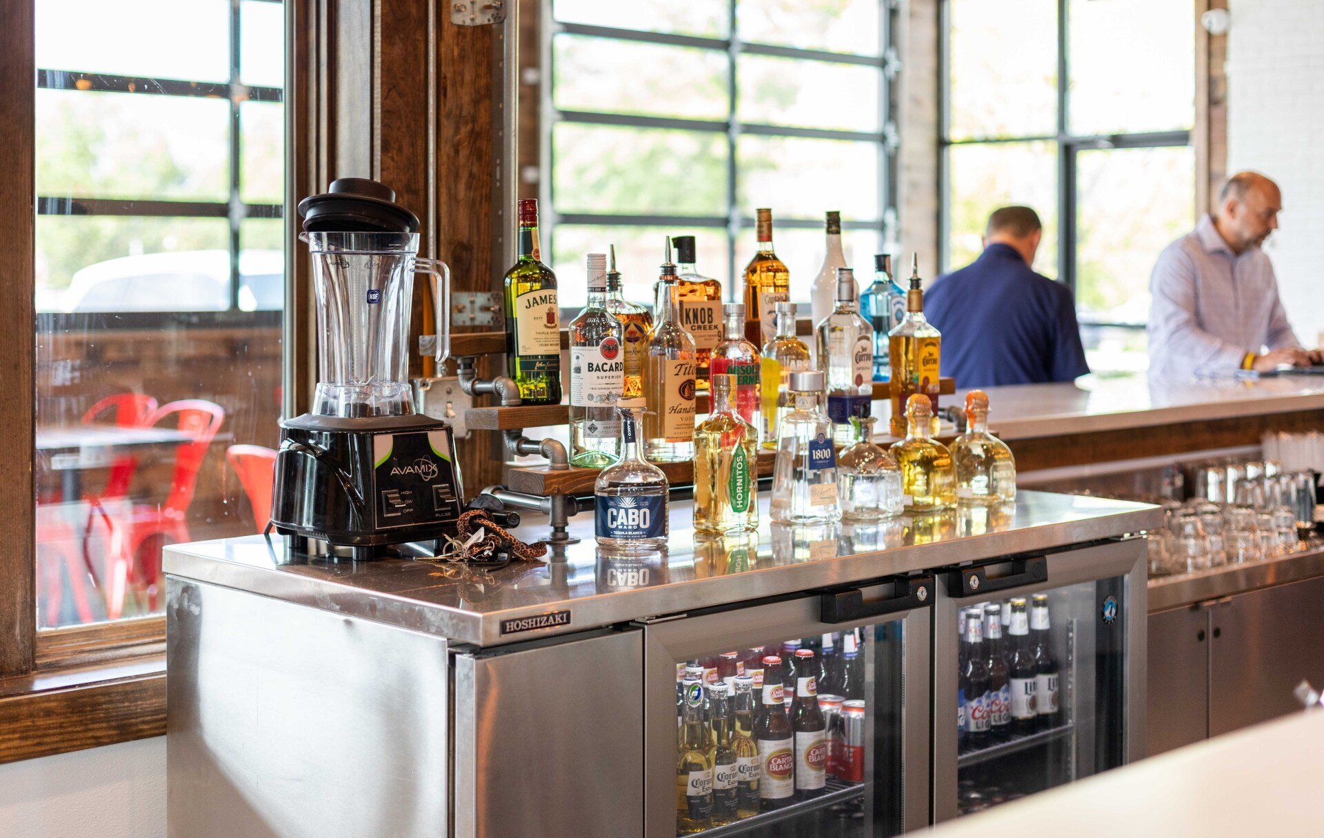 A bar filled with bottles of liquor and a blender.