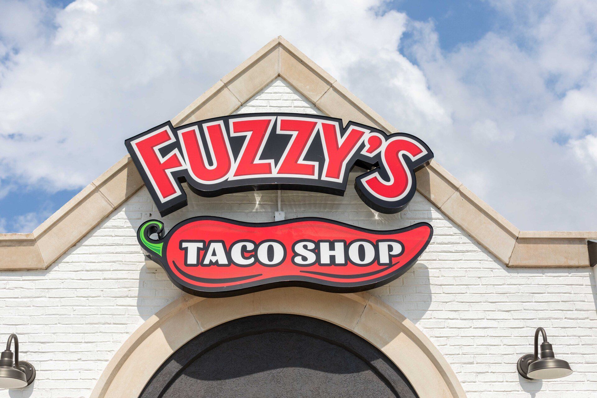 Fuzzy 's taco shop is located on a white brick building