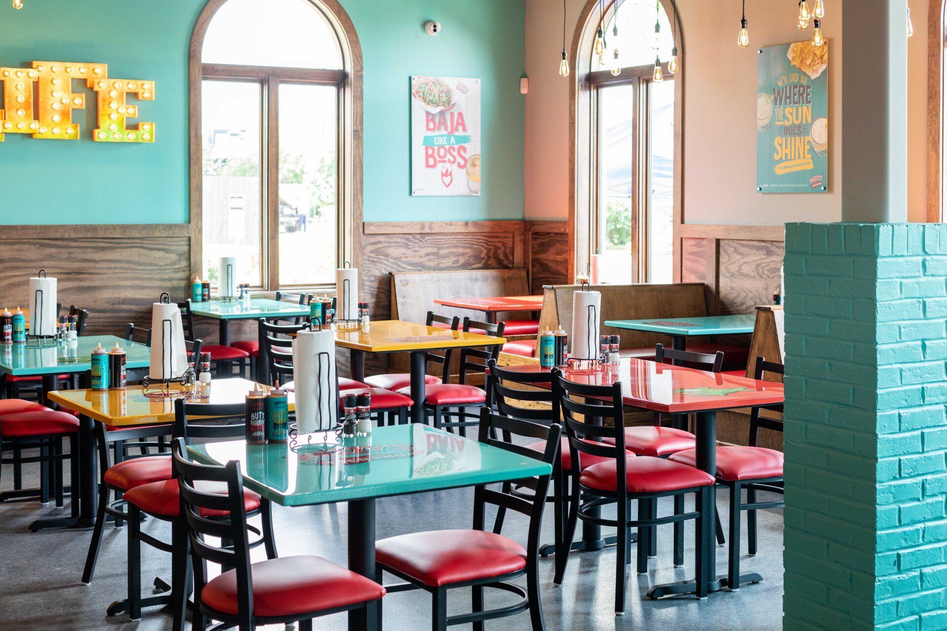 A restaurant with tables and chairs and a sign that says life on the wall.