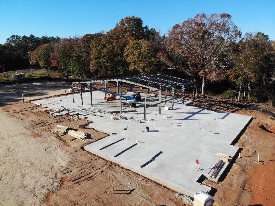 An aerial view of a construction site with trees in the background