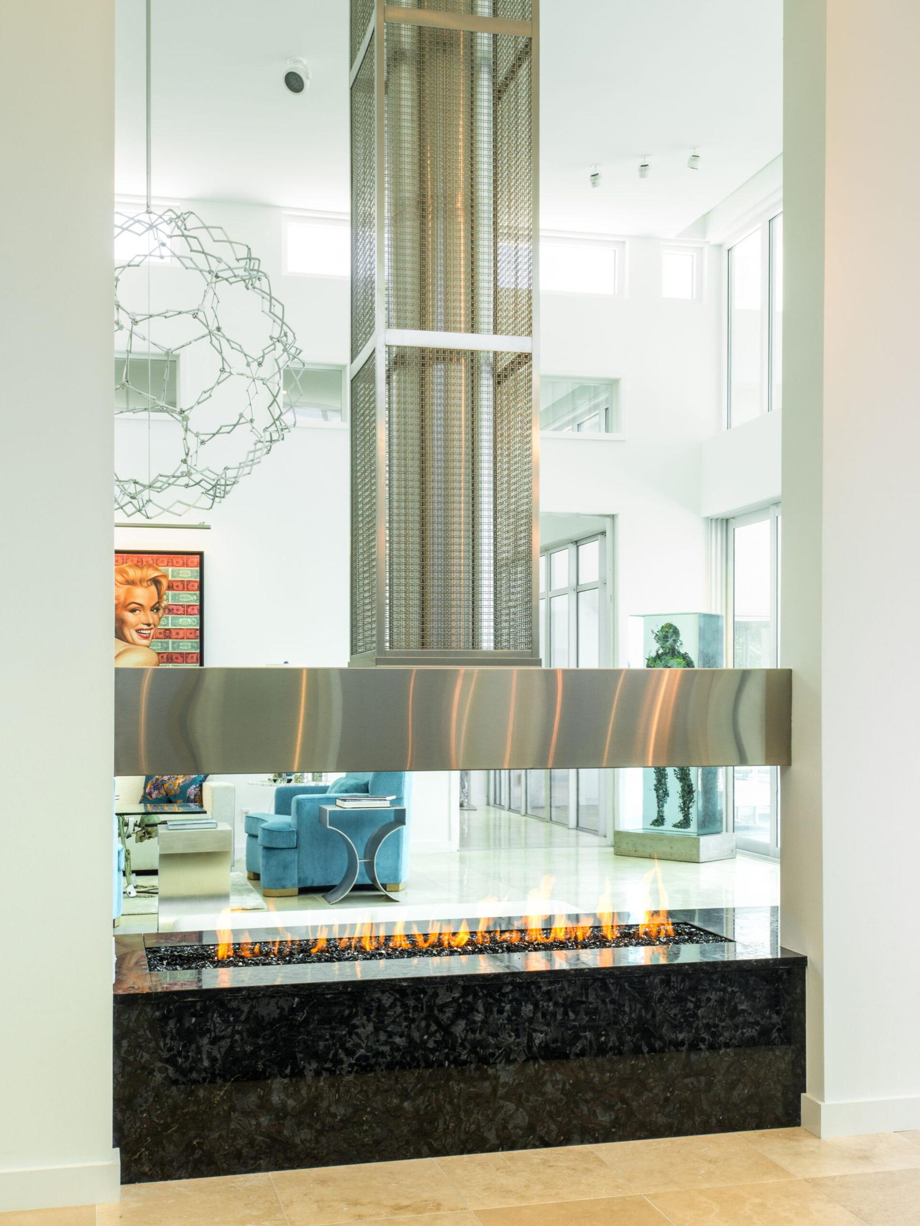 Modern fireplace with flames, stainless steel accents, and a granite base. Interior design.