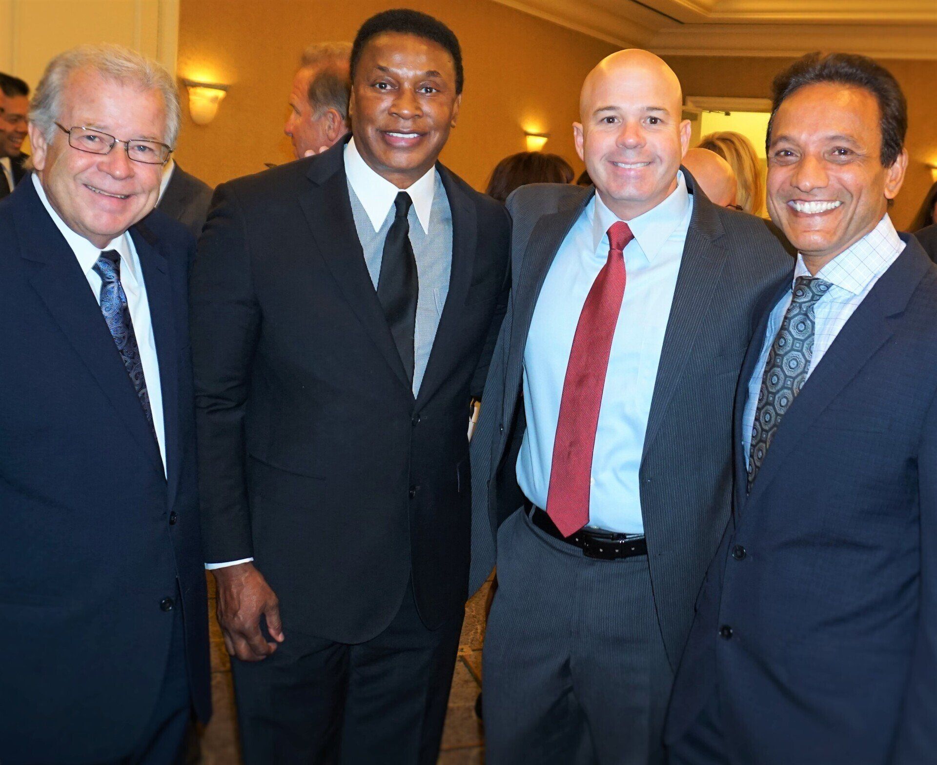 A group of men in suits and ties pose for a picture
