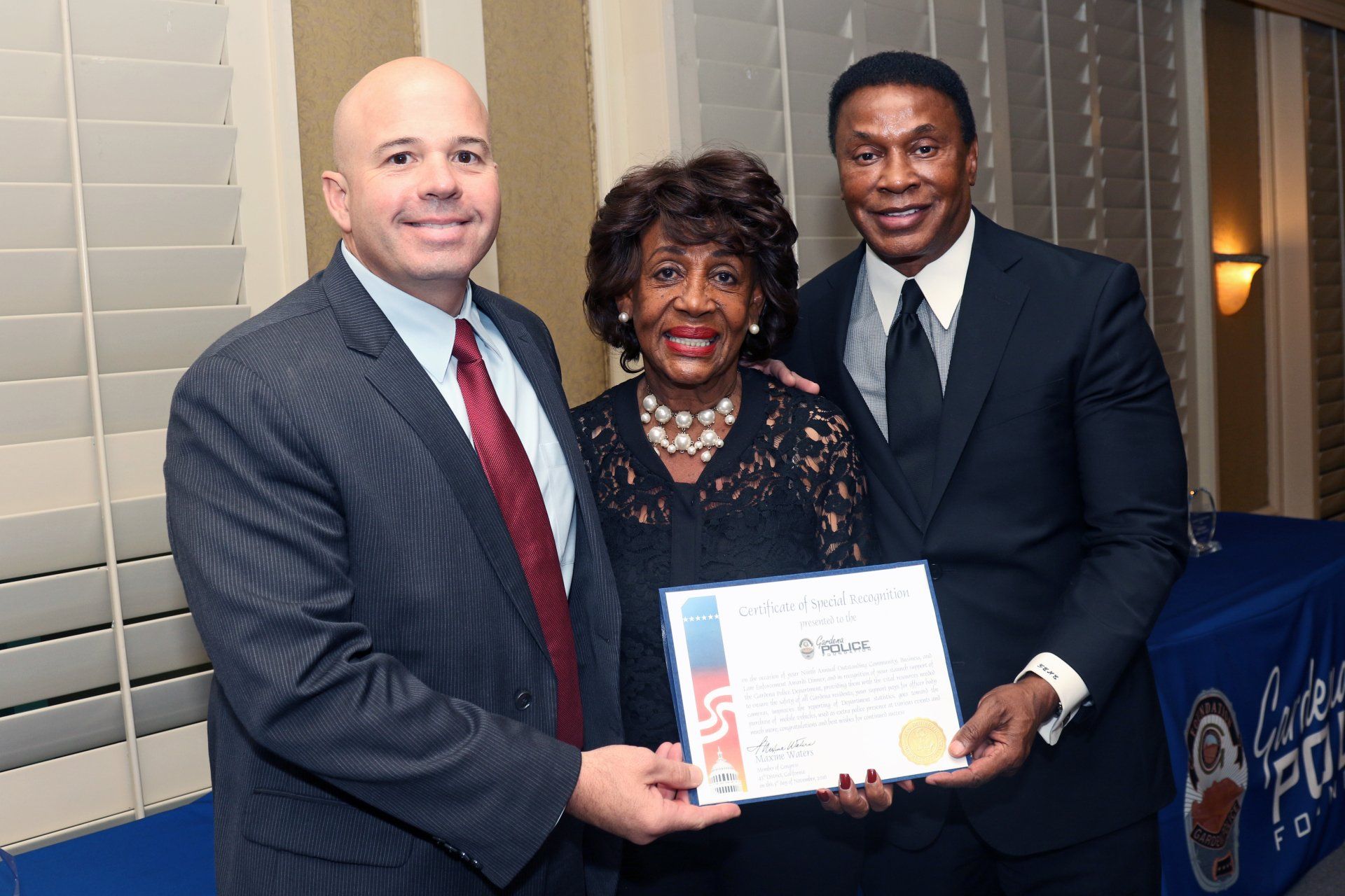 A man in a suit and tie is giving a certificate to a woman