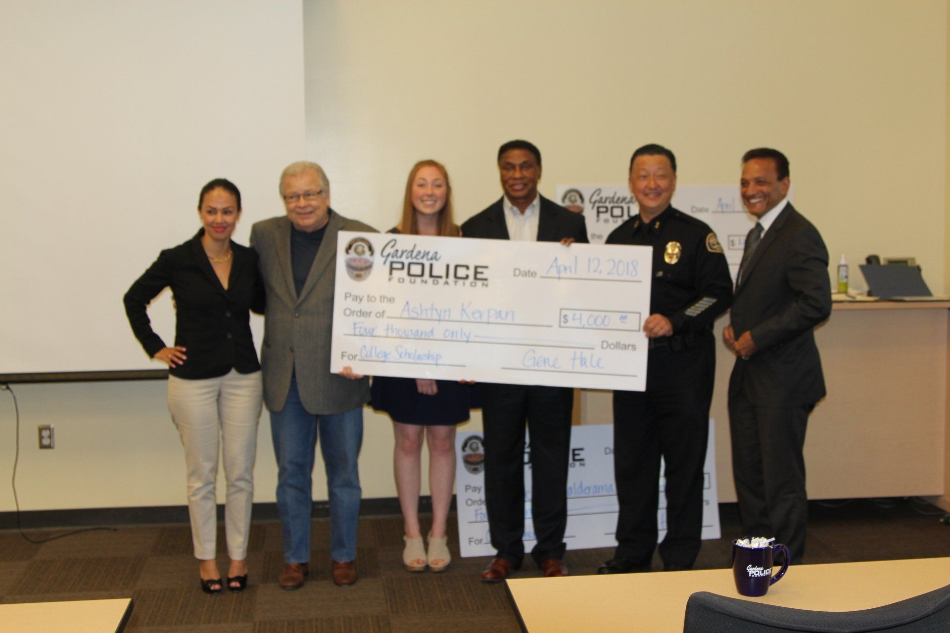 A group of people holding a large check that says police on it