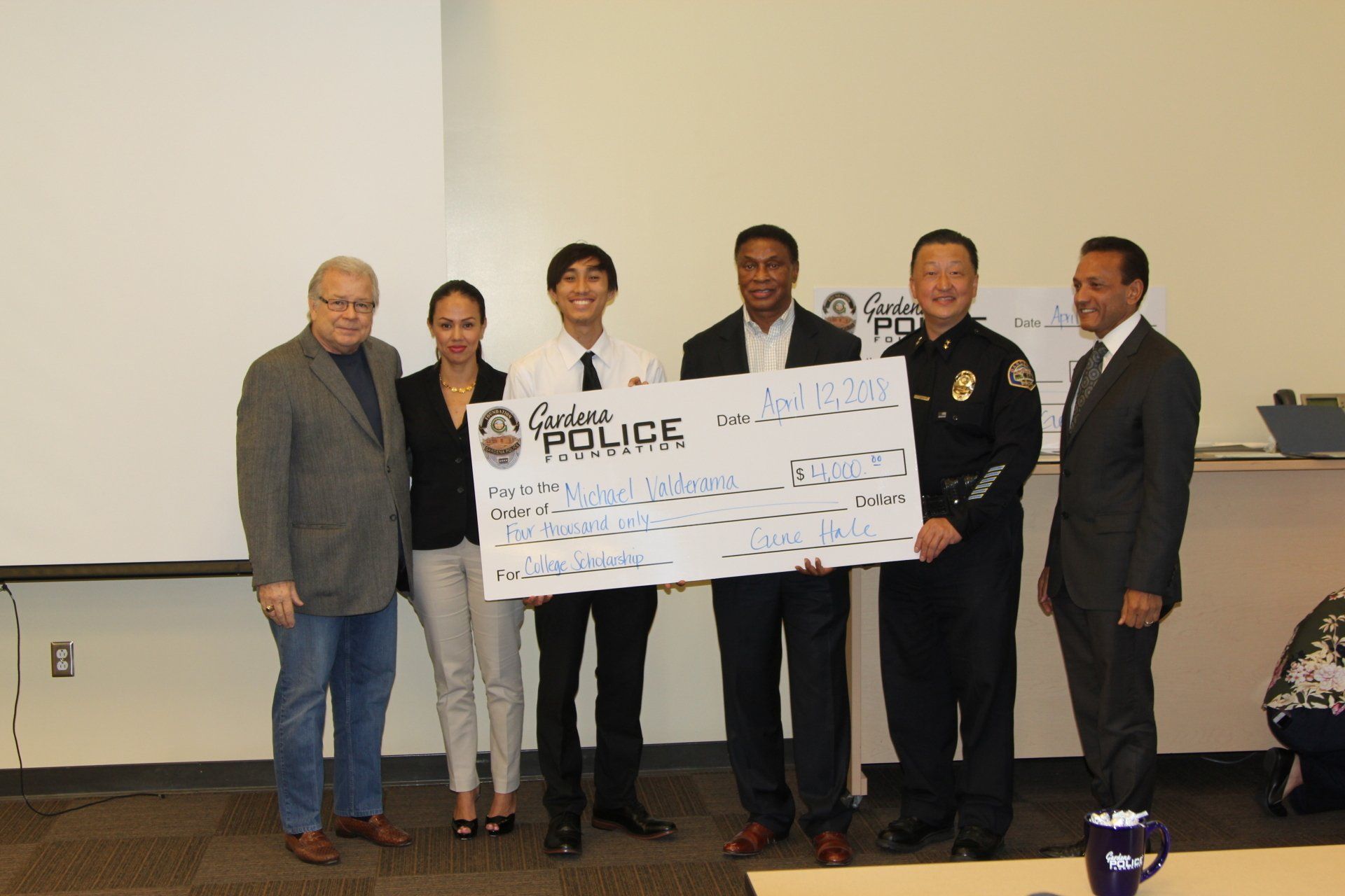 A group of people standing around a large check that says police on it