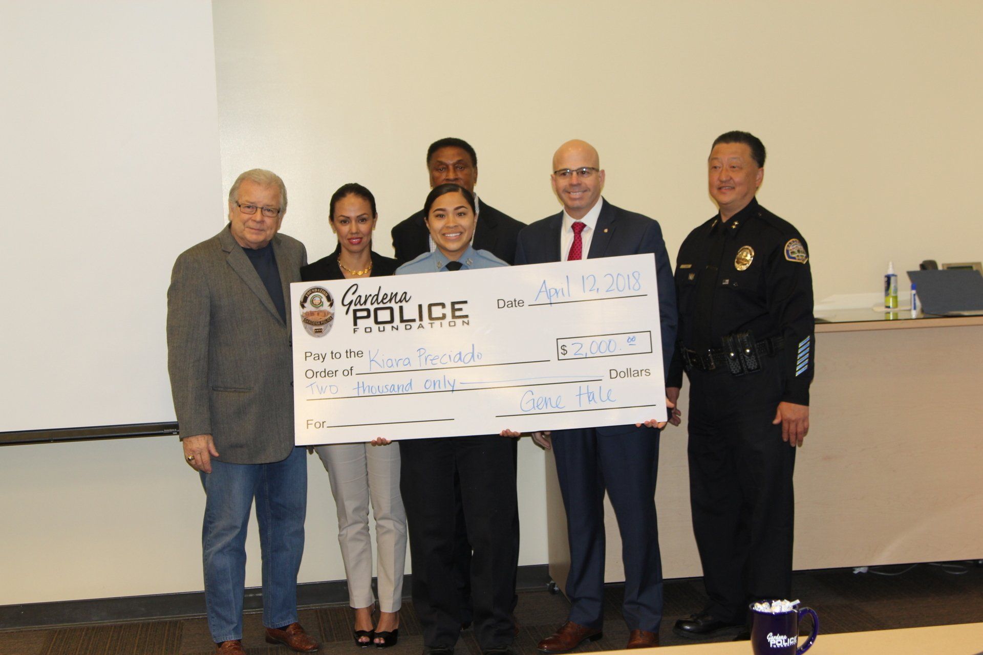 A group of people holding a large check that says police on it