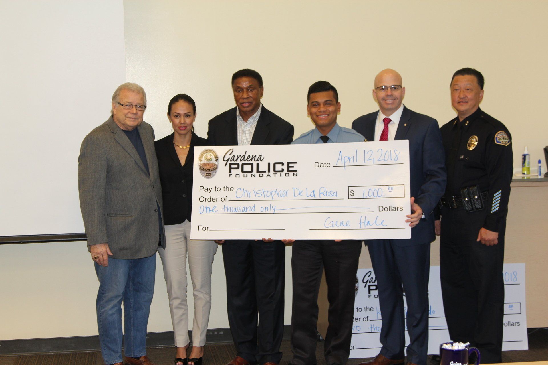 A group of people holding a check that says police on it