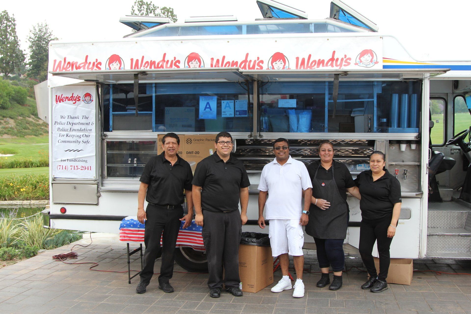 A group of people standing in front of a food truck