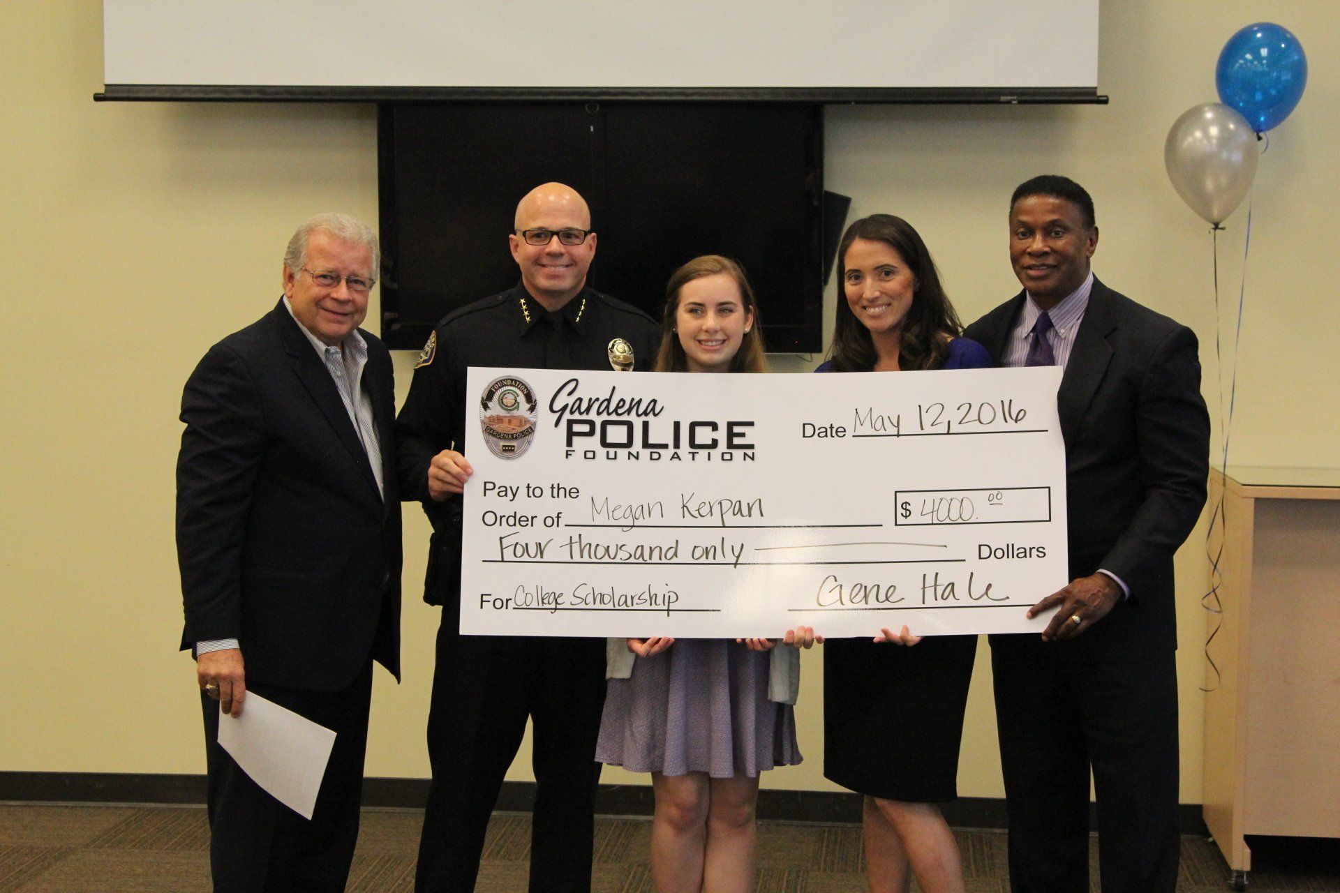 A group of people holding a large check that says cardona police