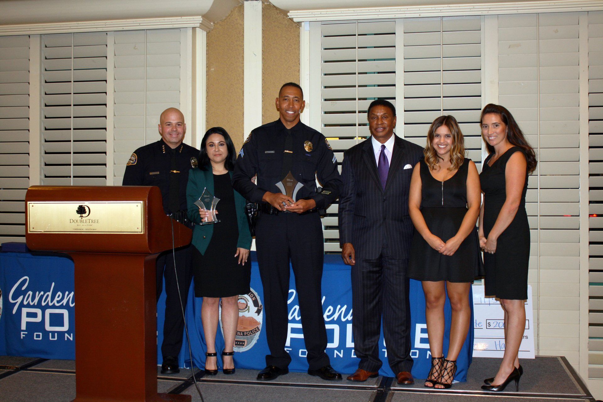 A group of people standing in front of a podium with the word garden on it