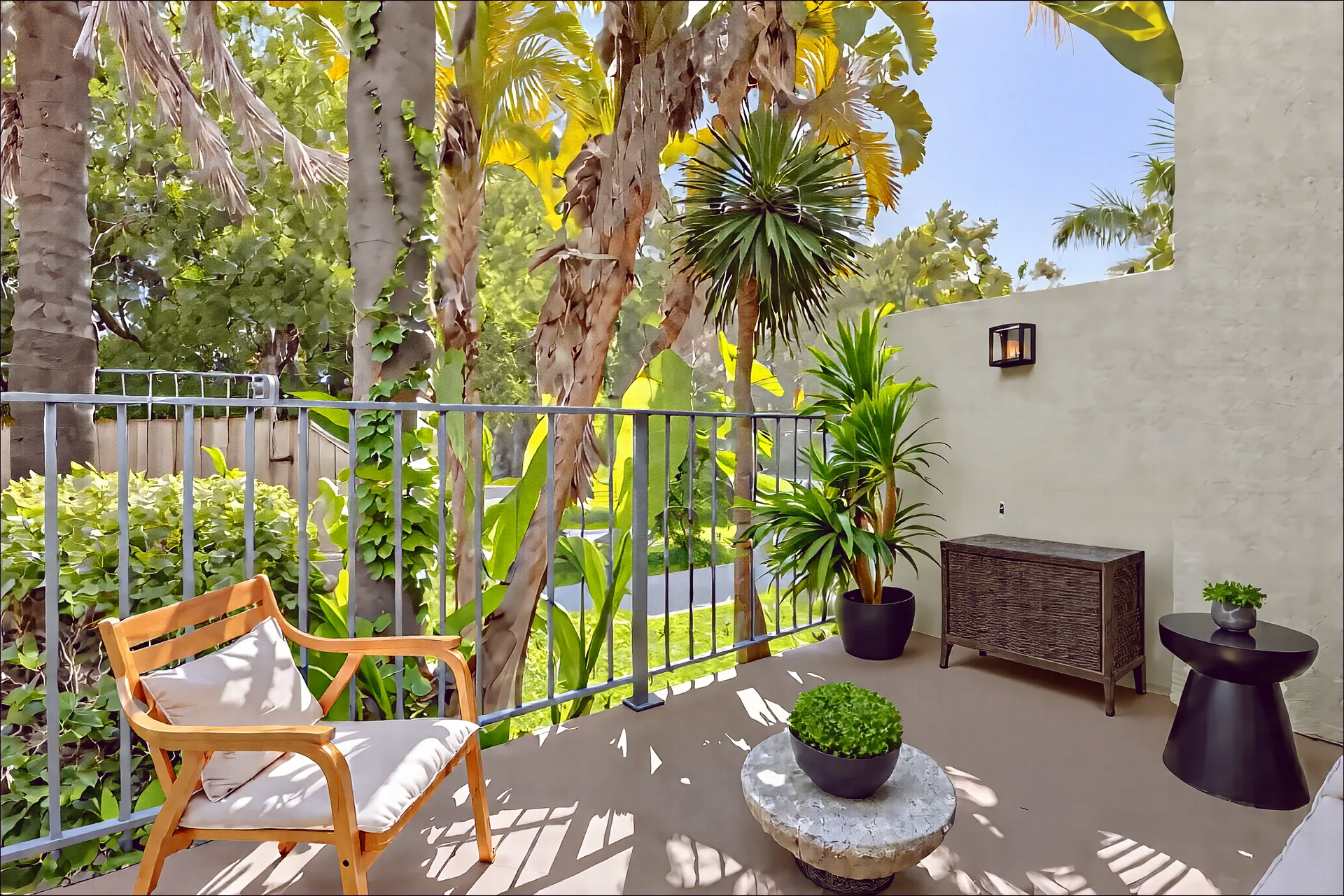 A balcony with a chair and a table with potted plants