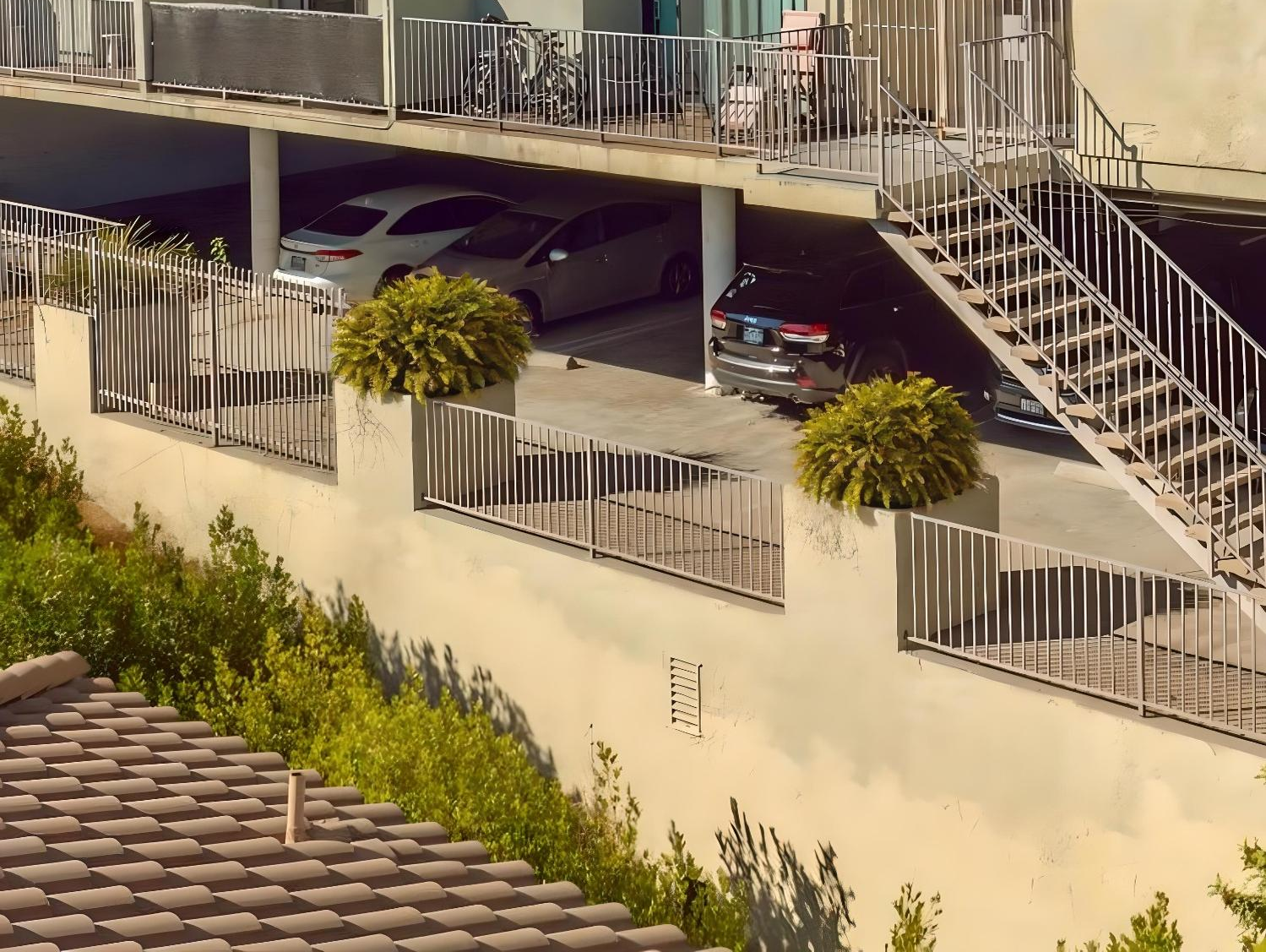 A building with stairs and cars parked underneath it