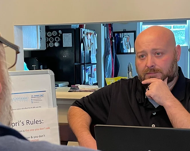 A woman is giving a man a massage on his back.